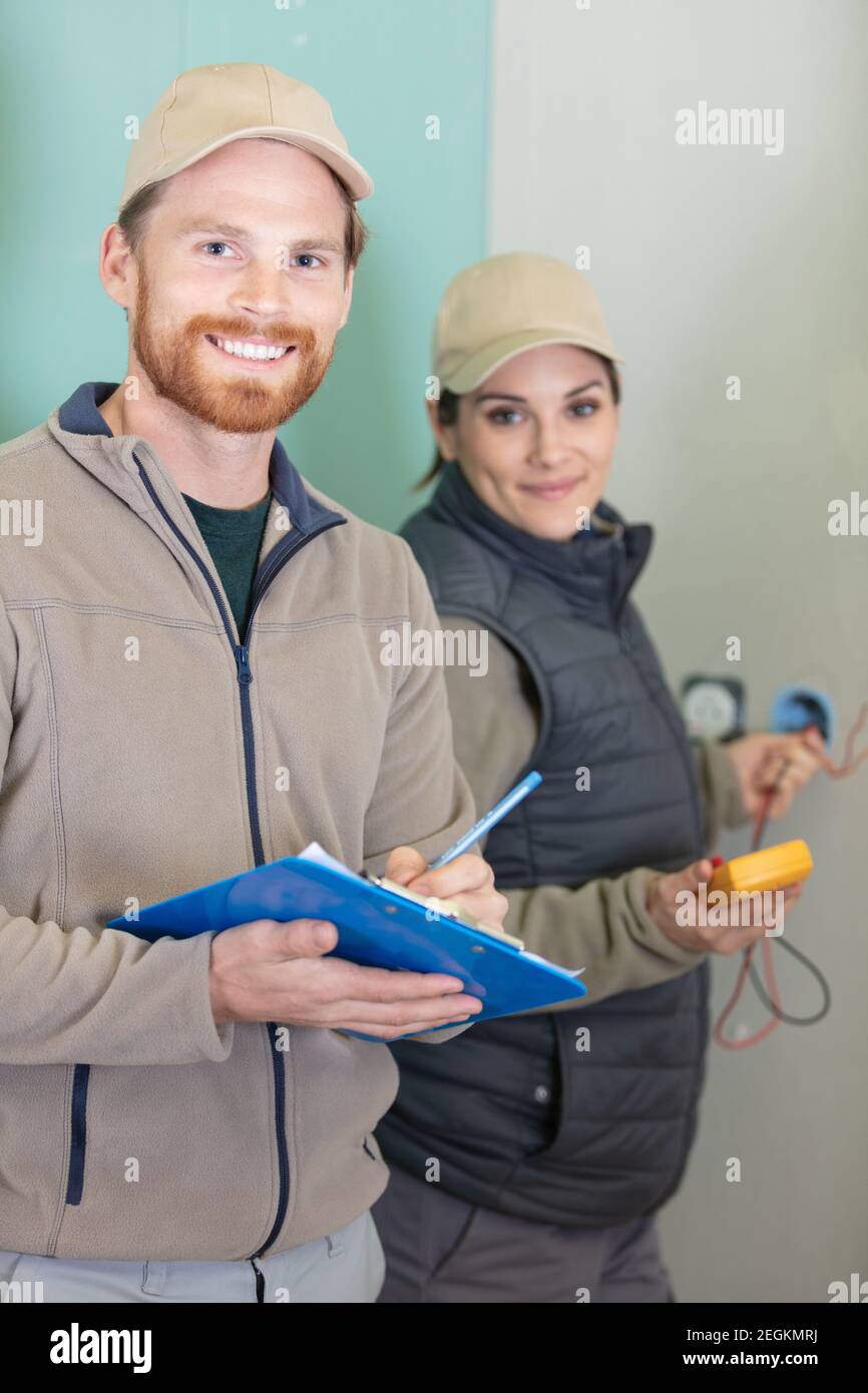 male and female electricians working together Stock Photo