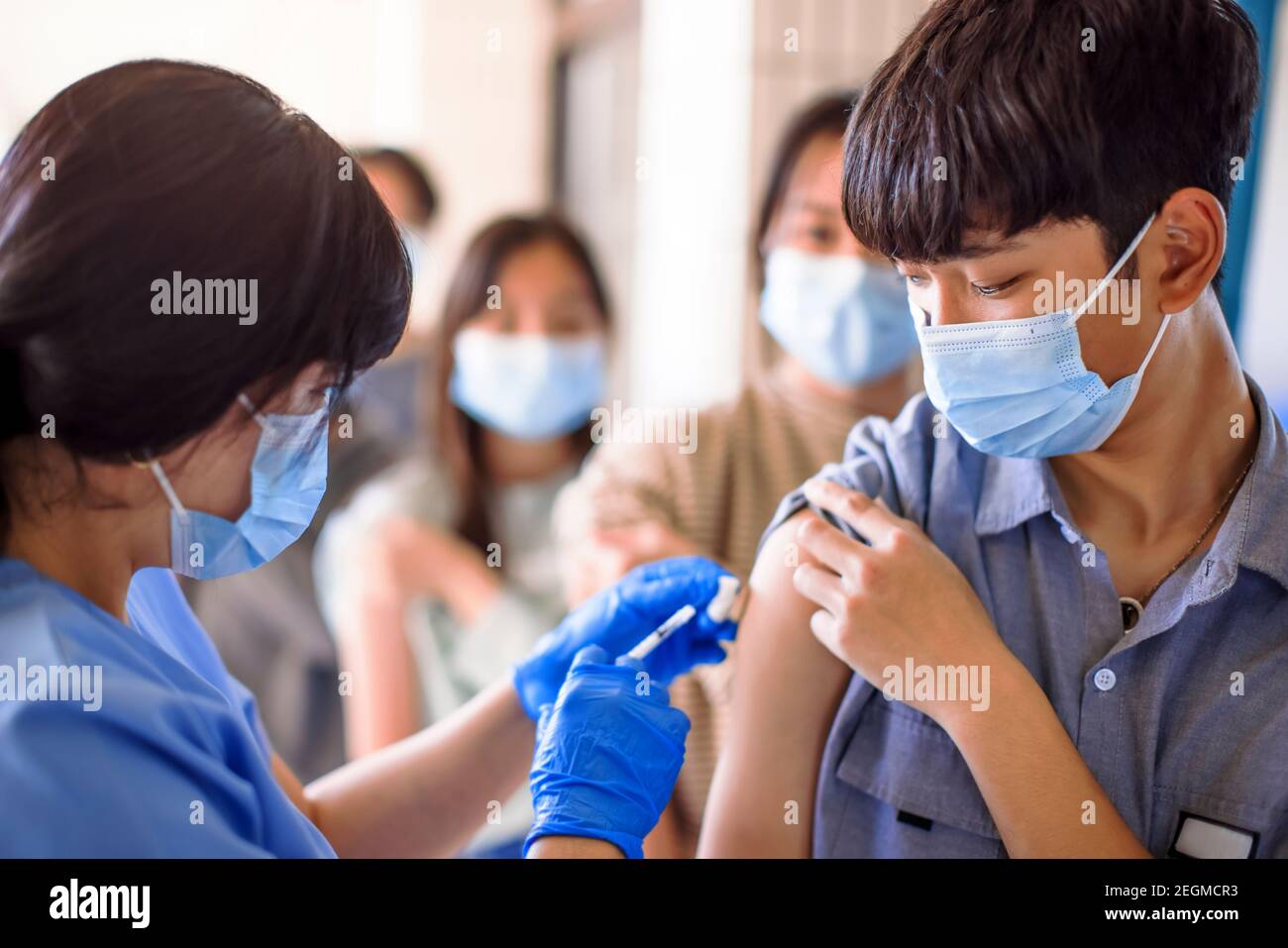 Doctor injecting vaccine for  students in high school Stock Photo