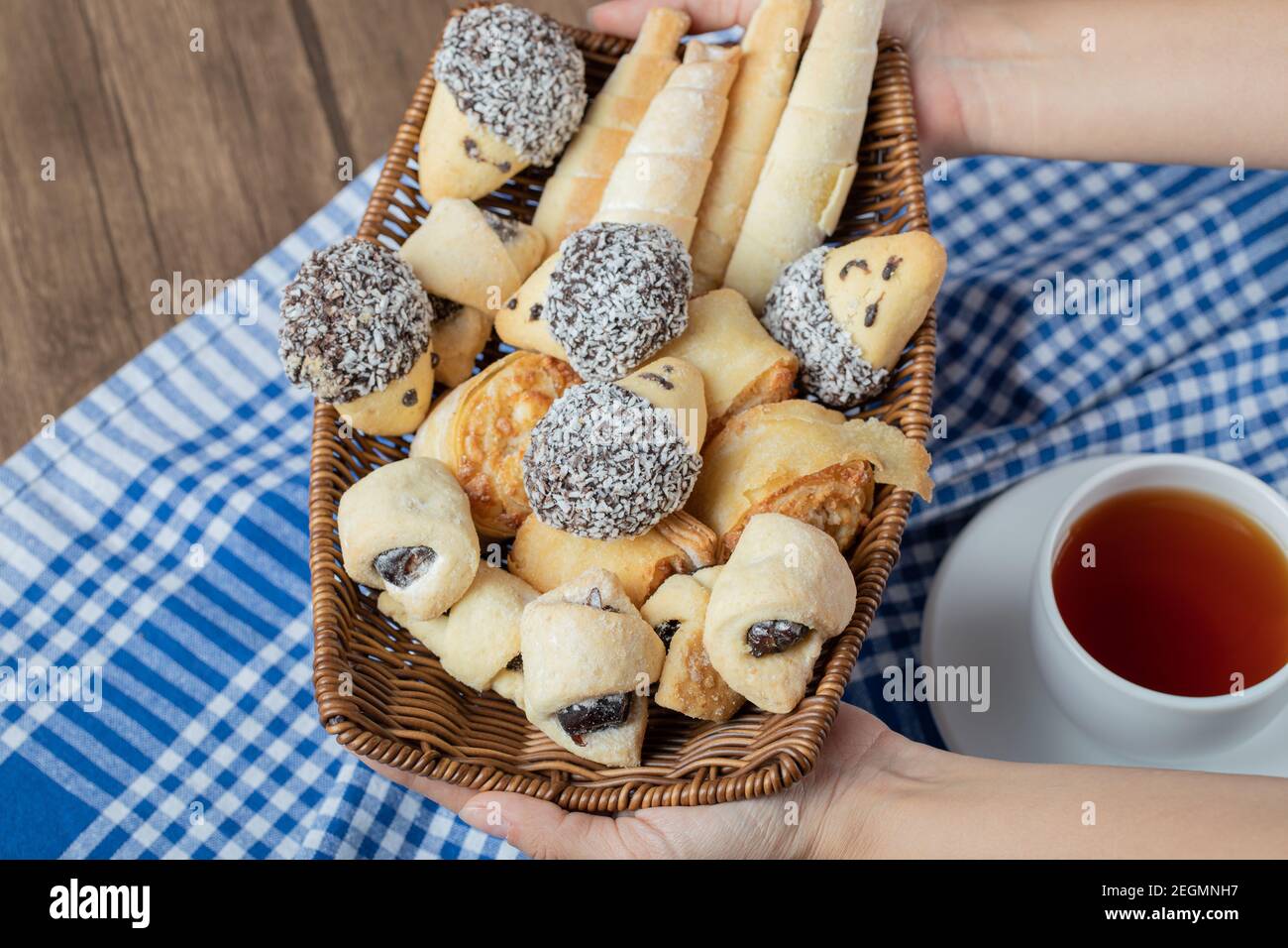 Chocolate sesame cookies in a wooden basket with a cup of earl grey tea