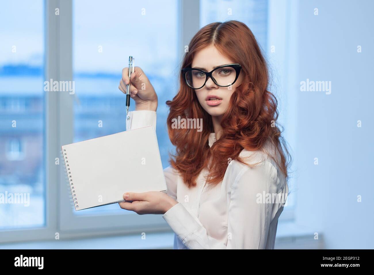 Business woman in white shirt with notepad in hands office documents ...