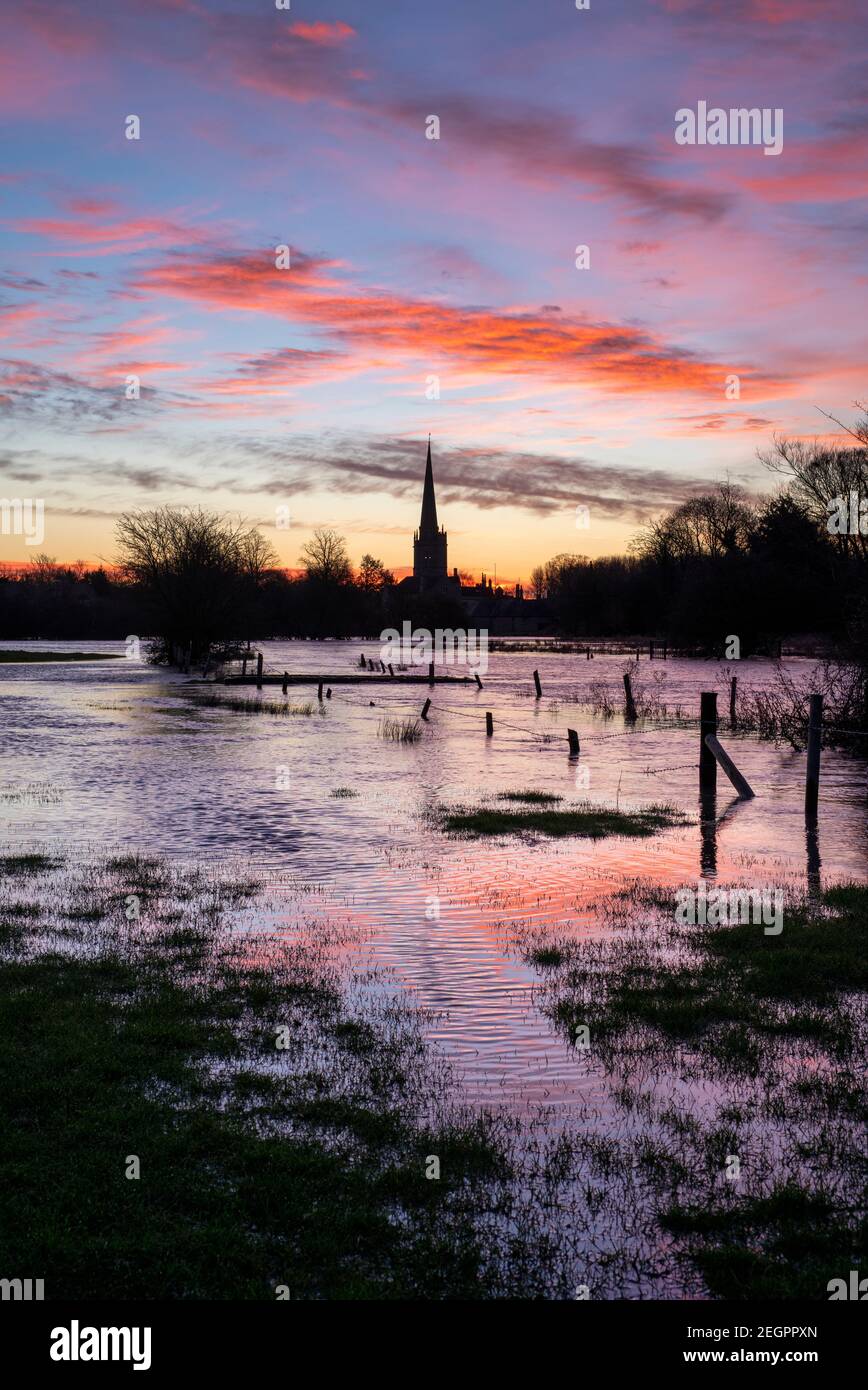Burford Church reflected in a flooded river windrush at dawn in winter. Burford, Cotswolds, Oxfordshire, England Stock Photo