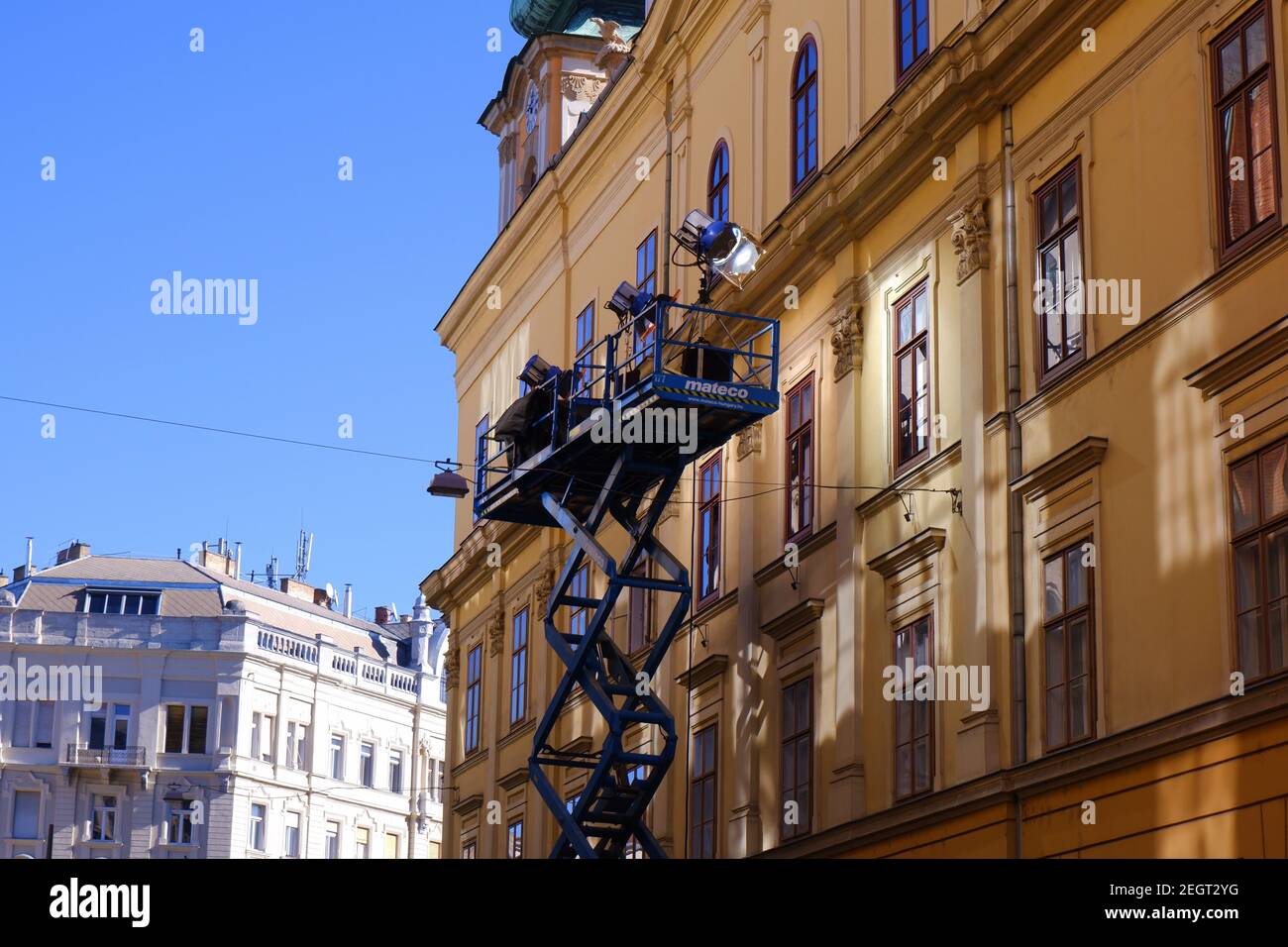 Budapest, Hungary - February 18, 2021: shooting scene with a crane with cameras and lighting in front of a downtown house on the street Stock Photo