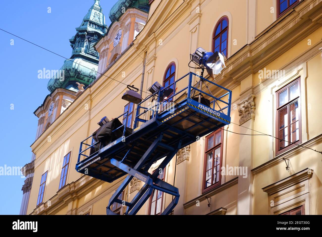 Budapest, Hungary - February 18, 2021: shooting scene with a crane with cameras and lighting in front of a downtown house on the street Stock Photo