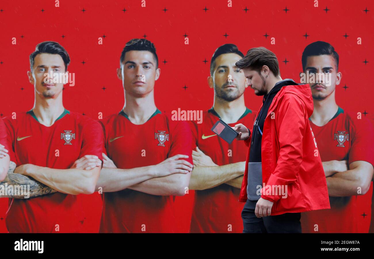 Soccer Football - World Cup - Portugal Team Training Camp  - Kratovo, Moscow, Russia - June 10, 2018   A volunteer walks past a image of Portugal's Cristiano Ronaldo and team mates before Portugal team training   REUTERS/Sergei Karpukhin Stock Photo