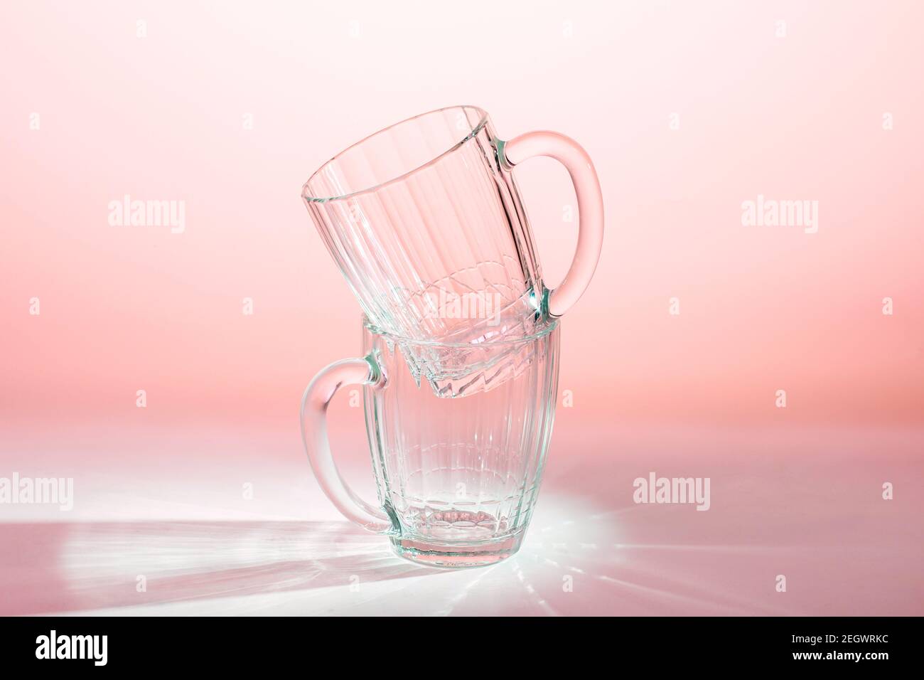 two empty beer glasses on table in pink light Stock Photo