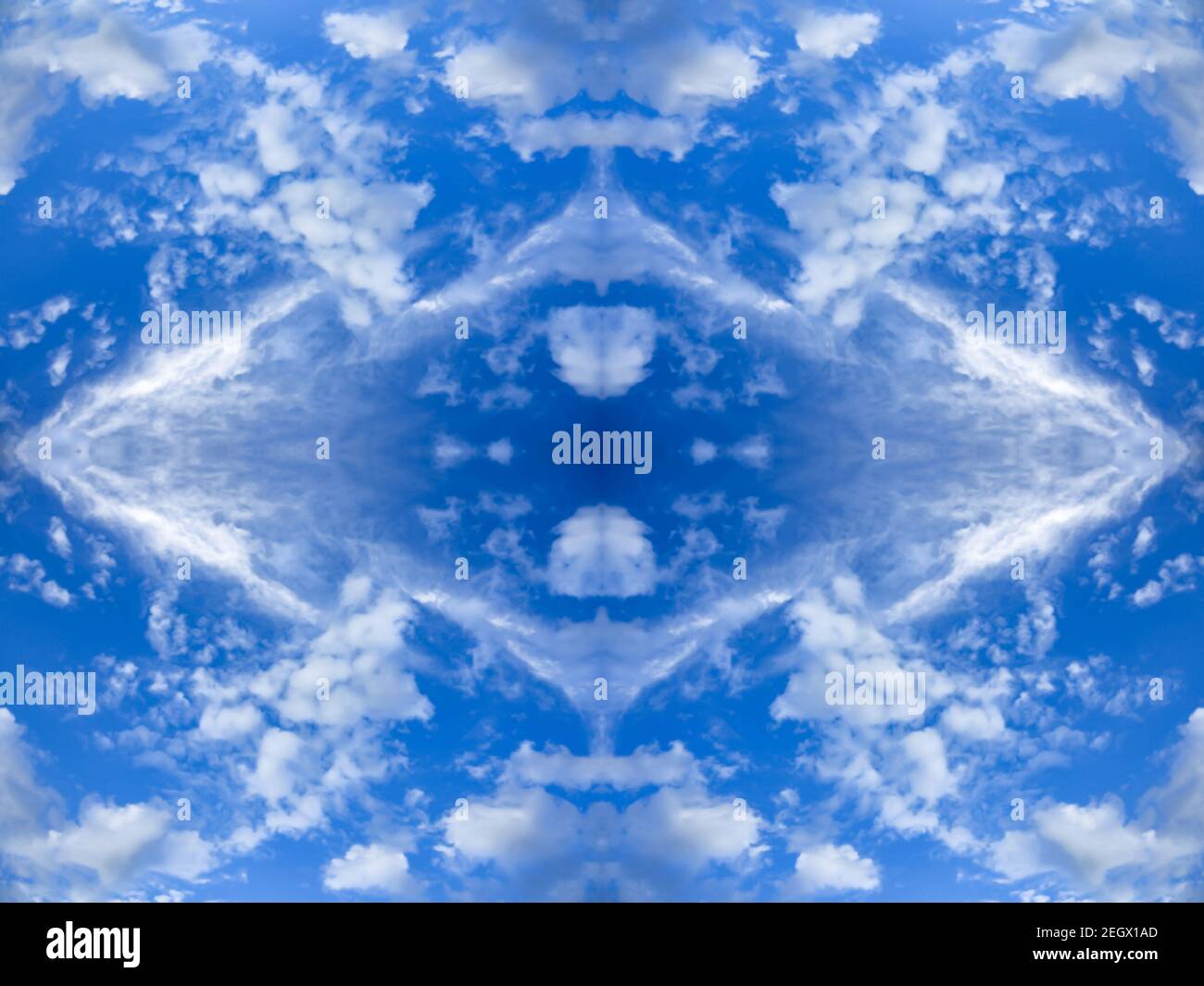 Blue sky with bright clouds. Mirror reflection, rhombus-shaped pattern. Blurred textured background with kaleidoscope effect. Abstract wallpaper Stock Photo