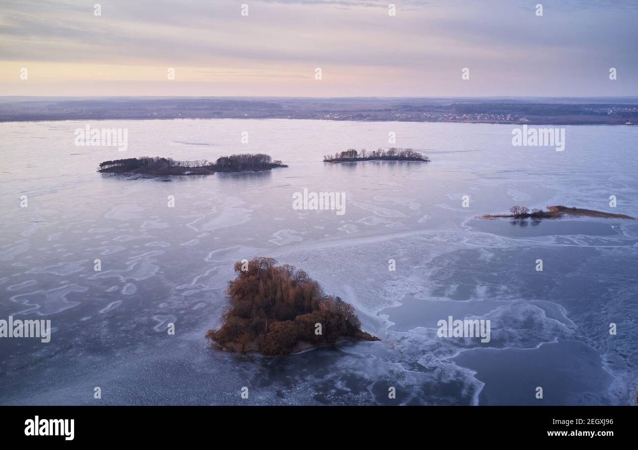 Ice on lake with small islands aerial drone view Stock Photo