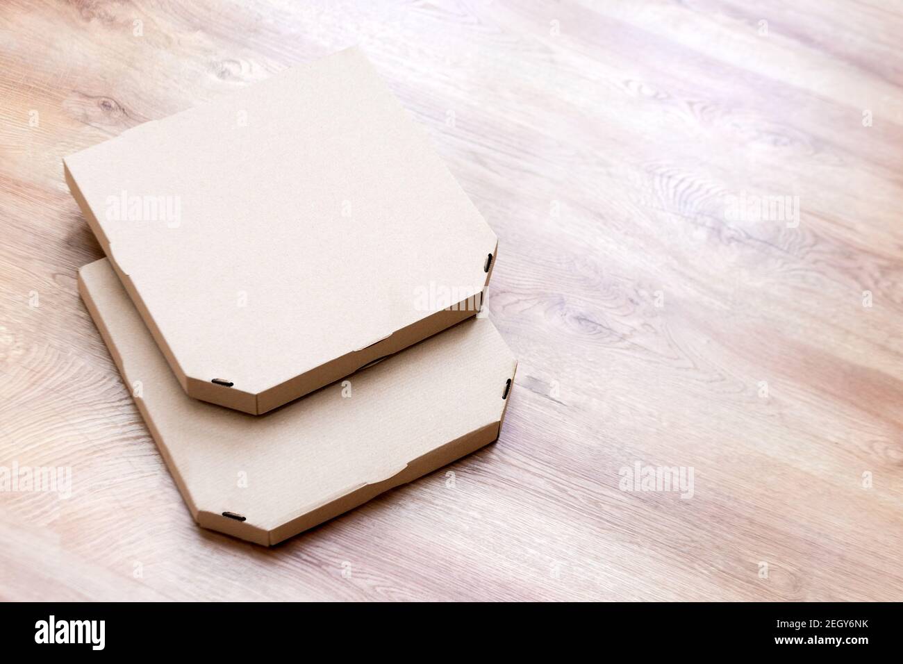 Take away pizza brown paper boxes on wooden background. Empty pizza
