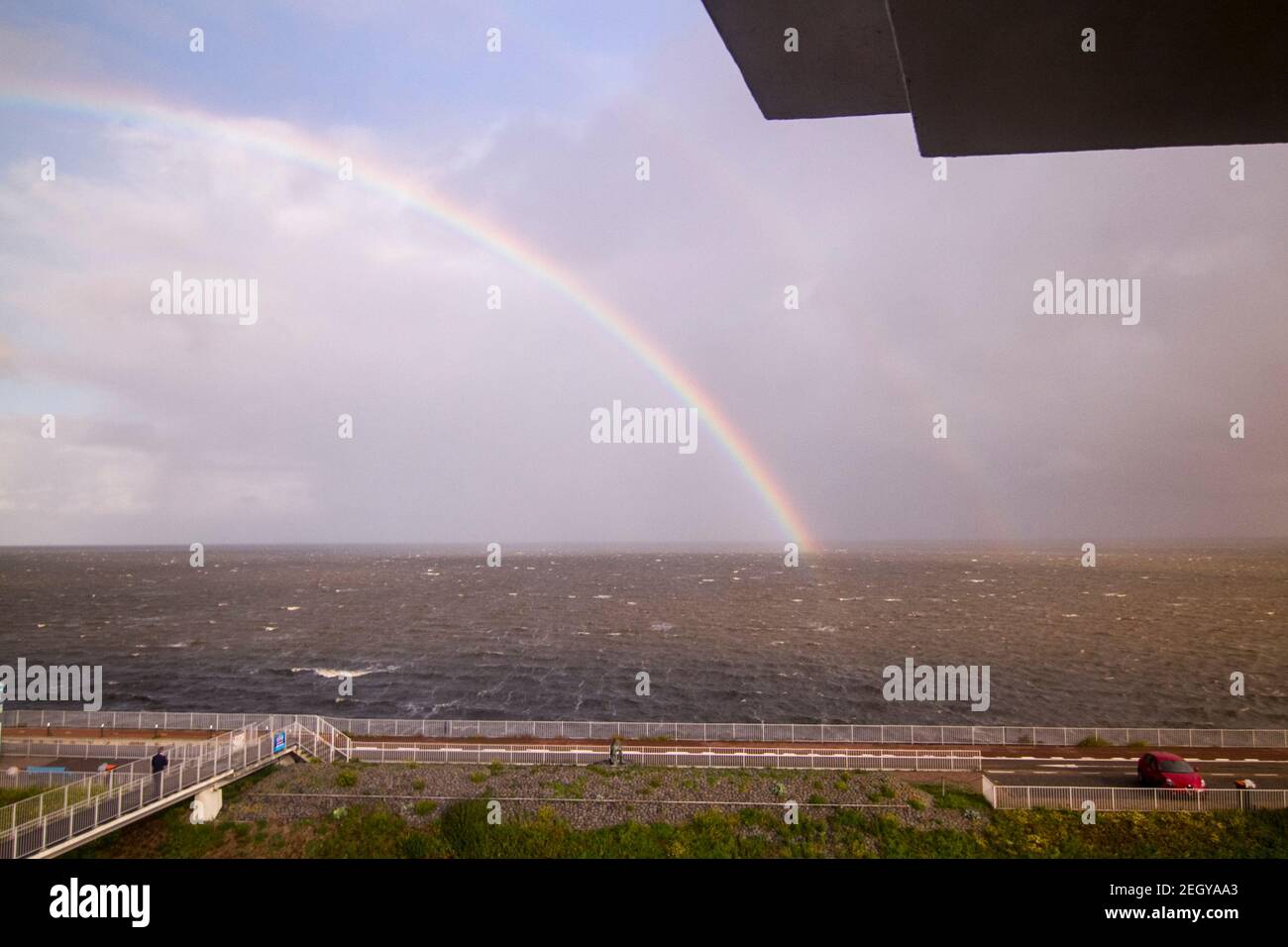 Rainbow at Afsluitdijk, a dam separating the North Sea from the Ijsselmeer lake. View from bridge at Breezanddijk, an artificial island created by bui Stock Photo