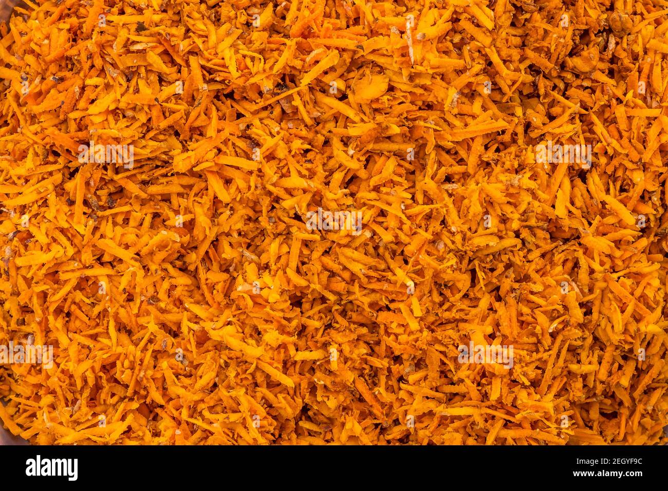 Background of shredded or grated turmeric roots into fine pieces for medicinal and food purpose. Stock Photo