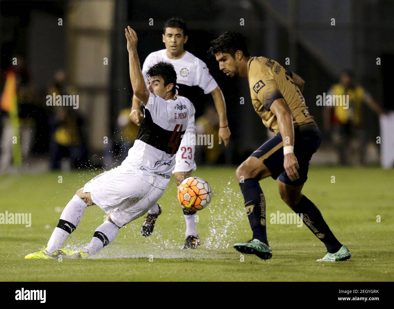 Football Soccer -Mexico's Pumas v Paraguay's Olimpia - Copa Libertadores - Defensores del Chaco Stadium, Asuncion, Paraguay, 1/3/2016   Eduardo Herrera (R) of Mexico's Pumas and Gustavo Mencia (C) of Paraguay's Olimpia fight for the ball. REUTERS/Jorge Adorno   Picture Supplied by Action Images Stock Photo