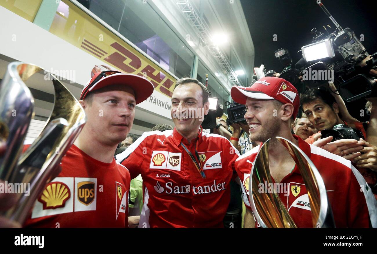 Ferrari Formula One drivers Sebastian Vettel (R) of Germany and Kimi Raikkonen (L) of Finland hold their trophies as they pose with teammate Riccardo Adami after the Singapore F1 Grand Prix at the Marina Bay street circuit September 20, 2015. REUTERS/Olivia Harris   Picture Supplied by Action Images Stock Photo
