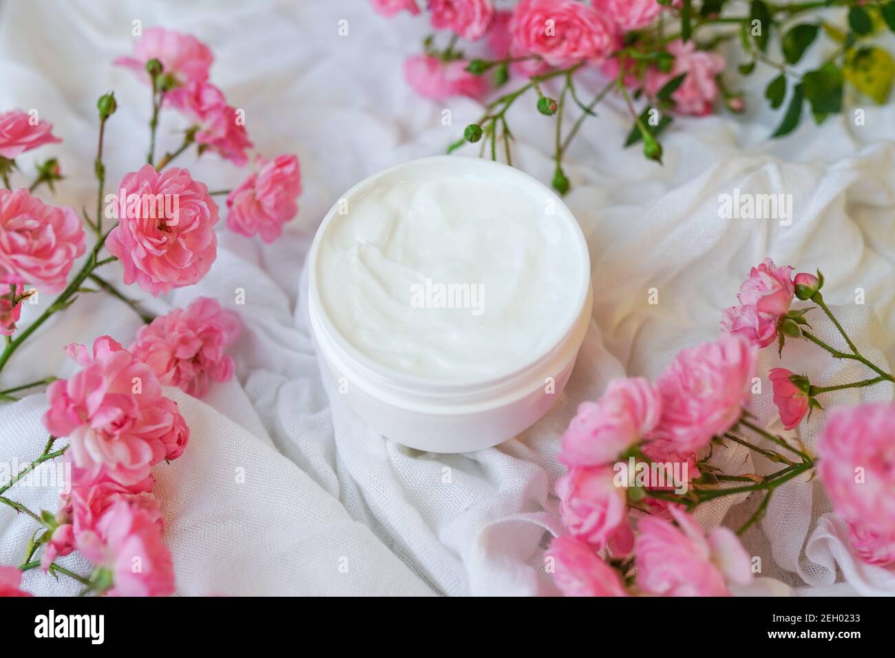 Face and body cream with pink roses on white Stock Photo