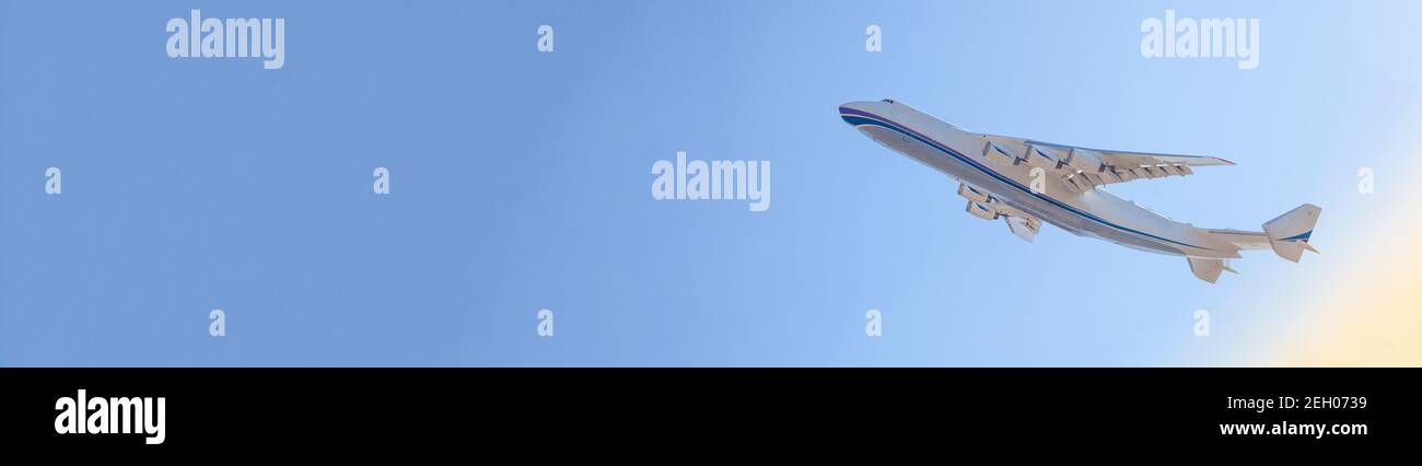 The plane takes off into the sky. Flight. Airplane banner. Large cargo plane. Travel and flights. Blue background. Card with Copy space Stock Photo