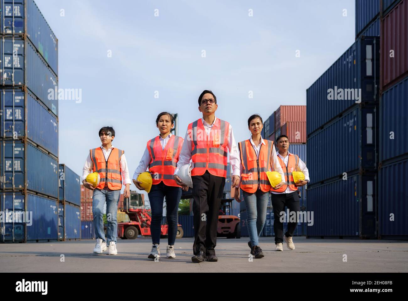 Asian foreman walking with four workers employee team after finishing ...