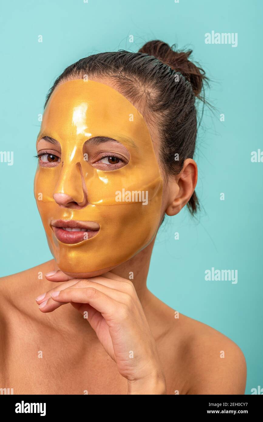 Beautiful woman using facial collagen gel skincare mask treatment Stock Photo