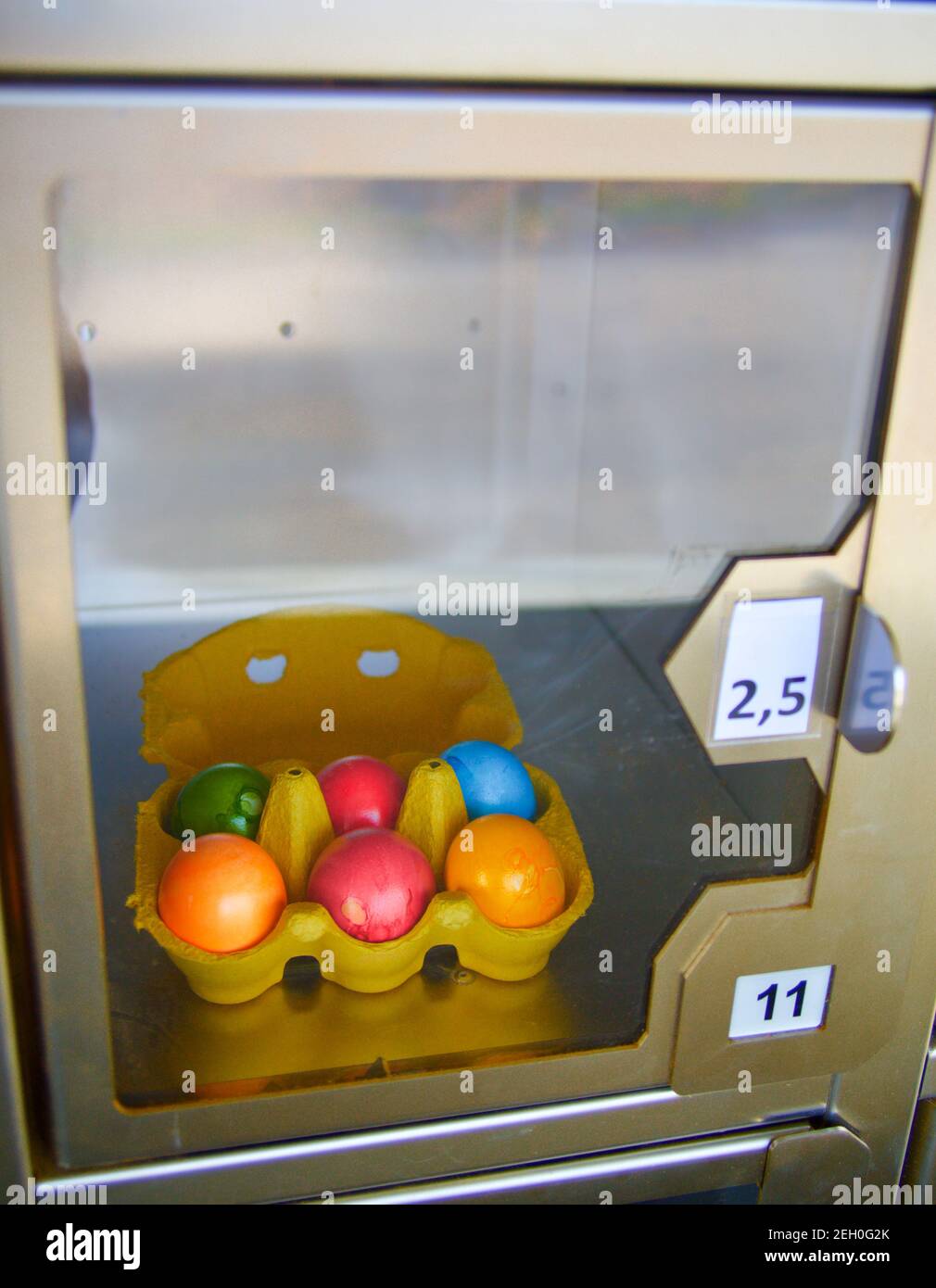 Coloured easter eggs behind glass in a self service machine Stock Photo