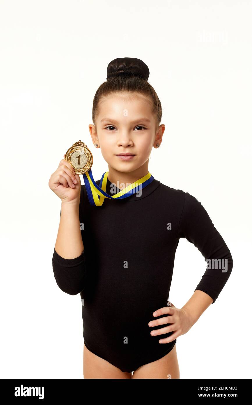 little gymnast girl in black bodysuit showing her gold medal isolated