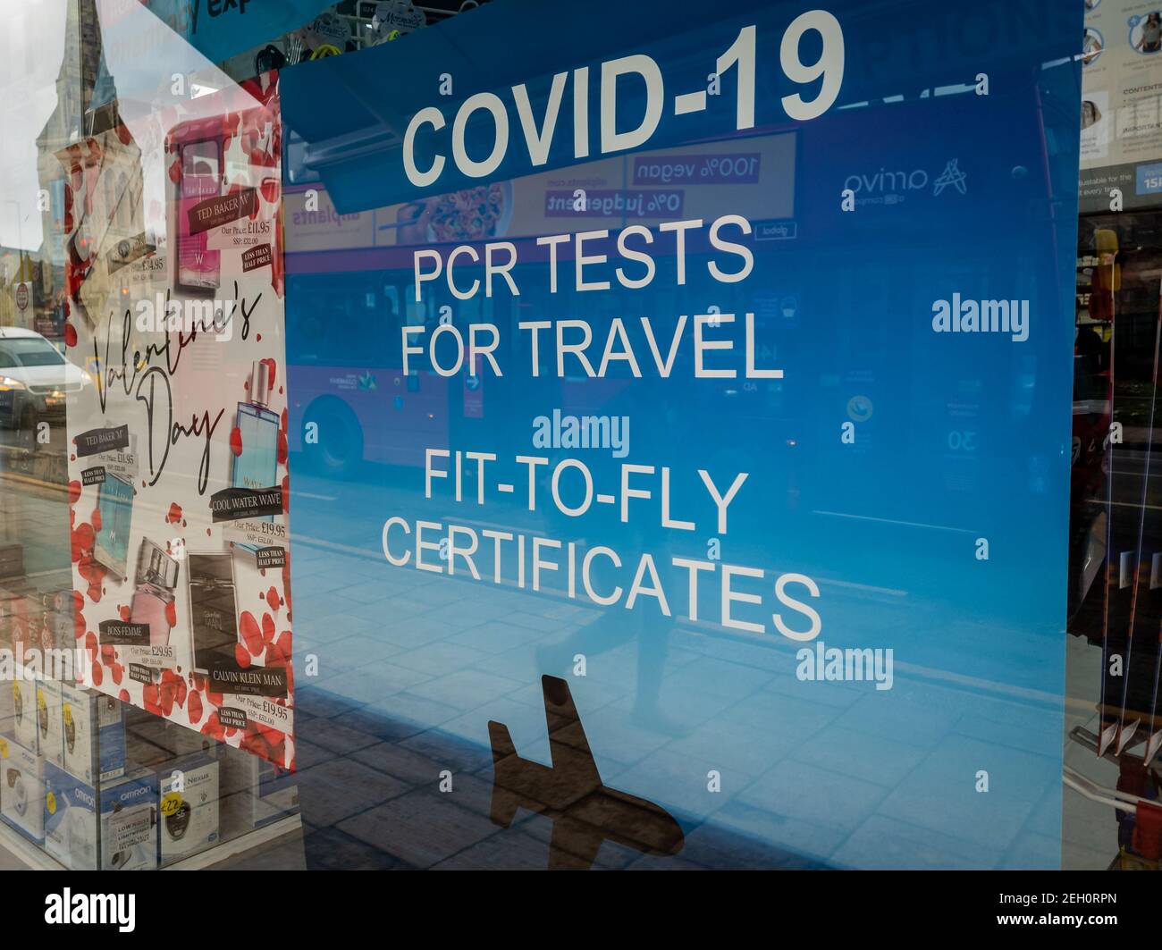 A poster in the window of a pharmacy offering commercial Covid-19 PCR test for travel. Stock Photo