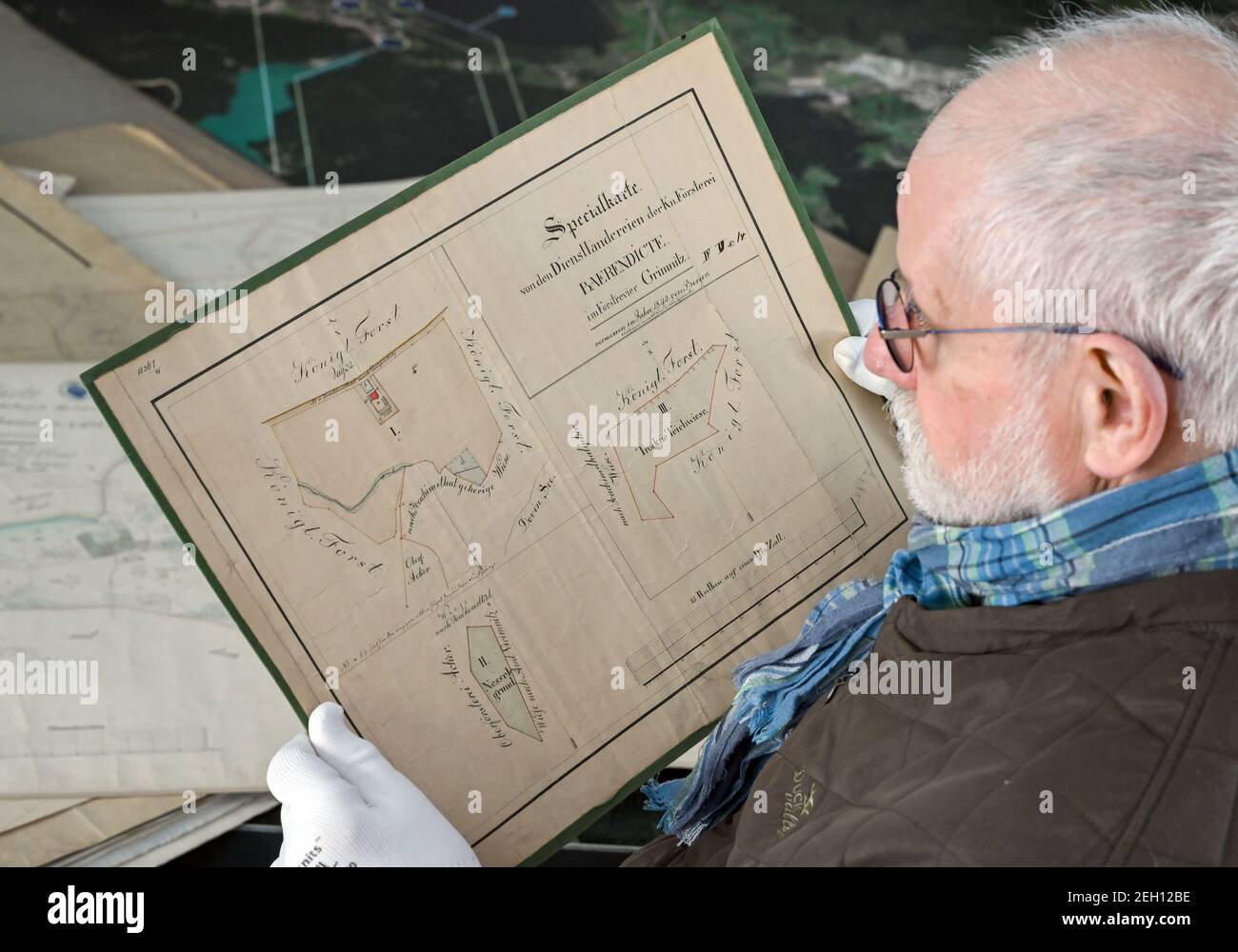 15 February 2021, Brandenburg, Groß Schönebeck: Helmut Suter, chairman of the Schorfheide Museum Association, looks at a historical forest map. On the grounds of the hunting lodge in Groß Schönebeck, the special history of this area rich in game becomes vivid. It ranges from the development of forestry to hunting and power, interwoven for almost 1,000 years. Photo: Patrick Pleul/dpa-Zentralbild/ZB Stock Photo