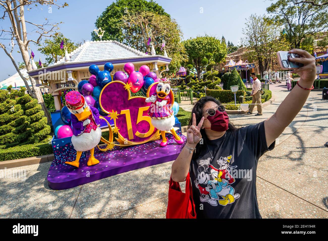 A female visitor takes a selfie while maintaining social distance with the actors dressed as the Disney cartoon characters of Donald Duck and Daisy Duck during the reopening of the Hong Kong Disneyland Resort.The Hong Kong Disneyland Resort reopens its door to visors as the city's government has relaxed the lockdown restrictions as the infection rate of the Covid-19 coronavirus has reduced significantly in recent days. Stock Photo