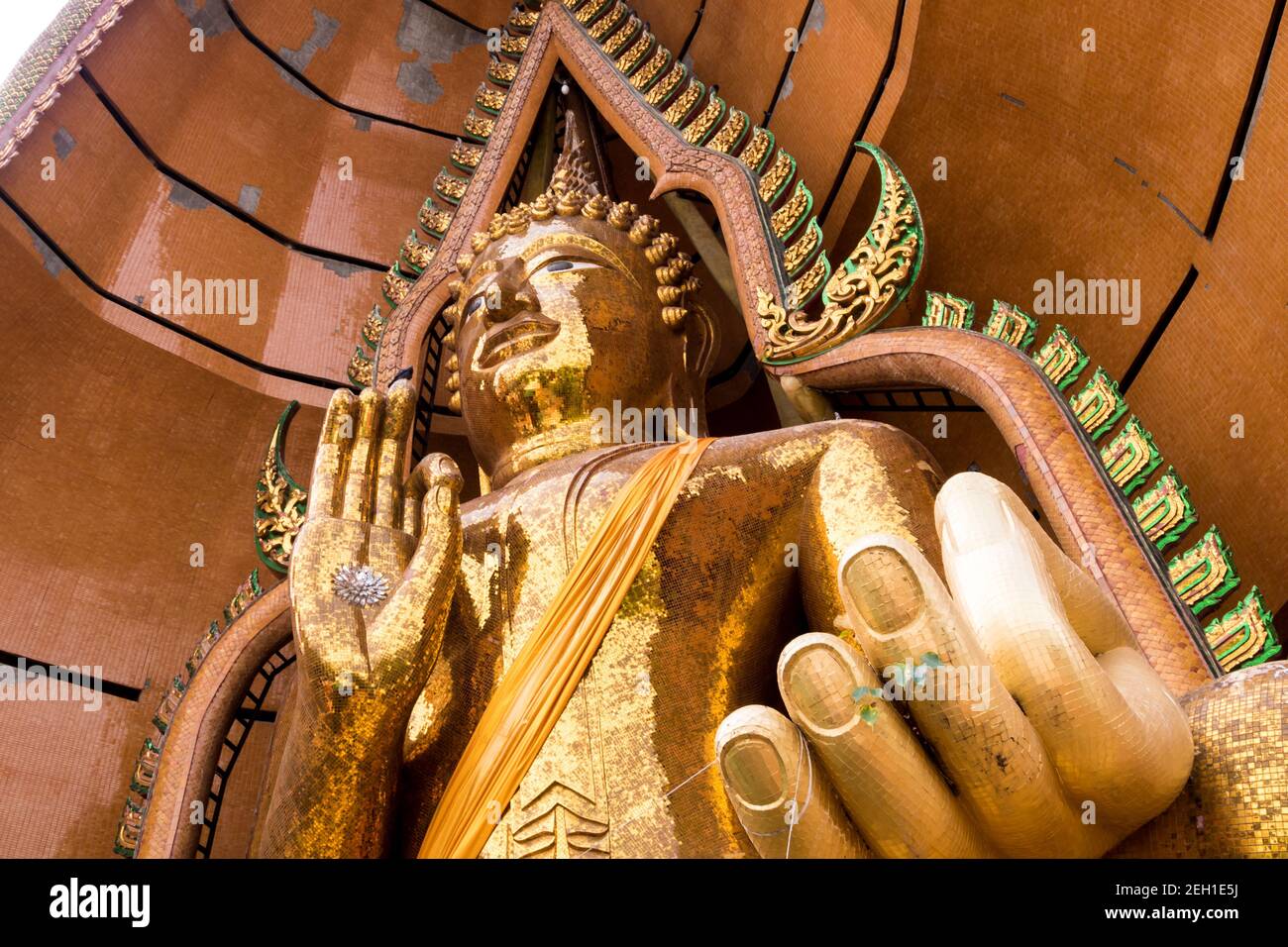 Silver chrysanthemum symbol and gold leaf In the palm of the Buddha statue Stock Photo