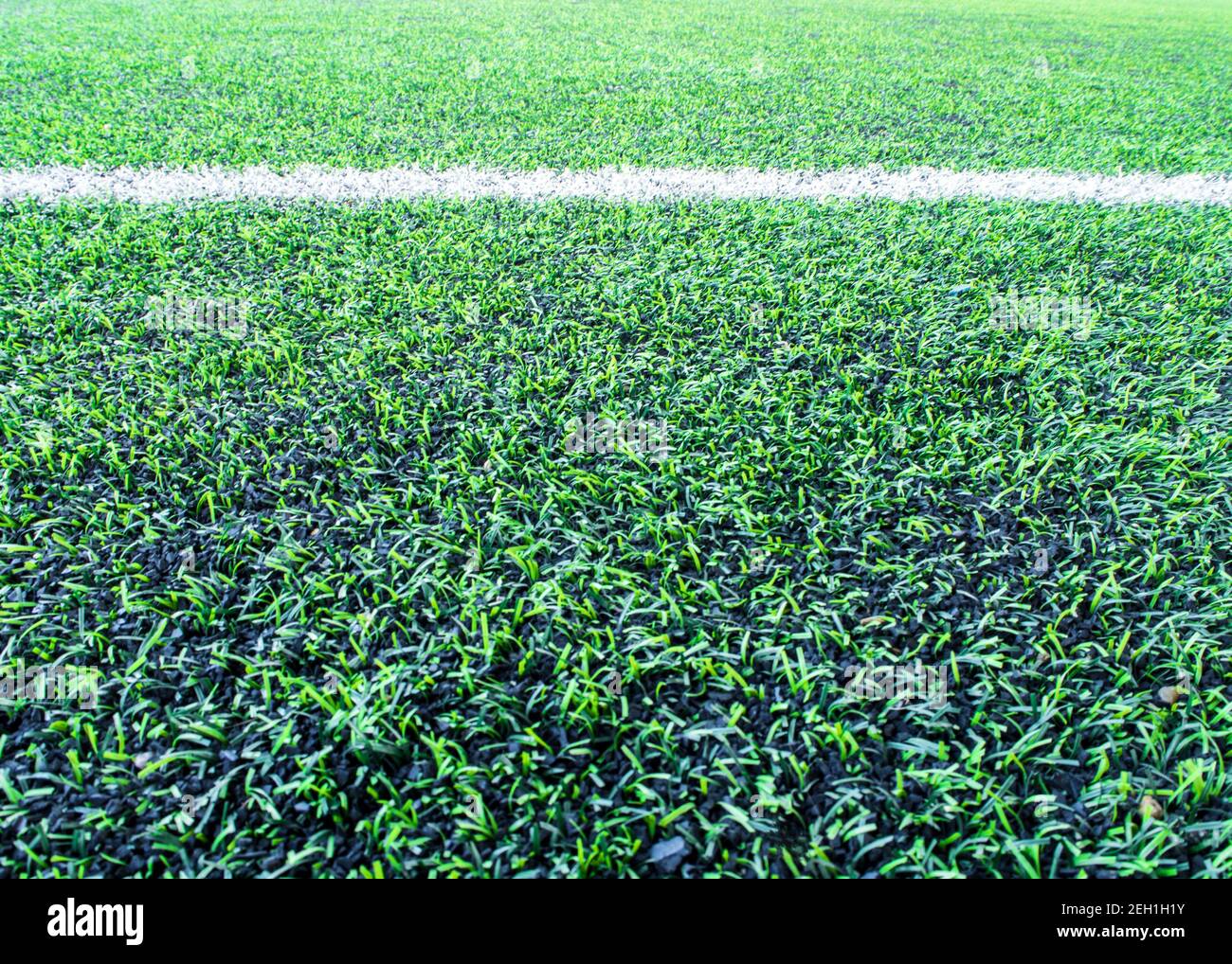 The texture of plastic artificial grass and the rubber pellets on the