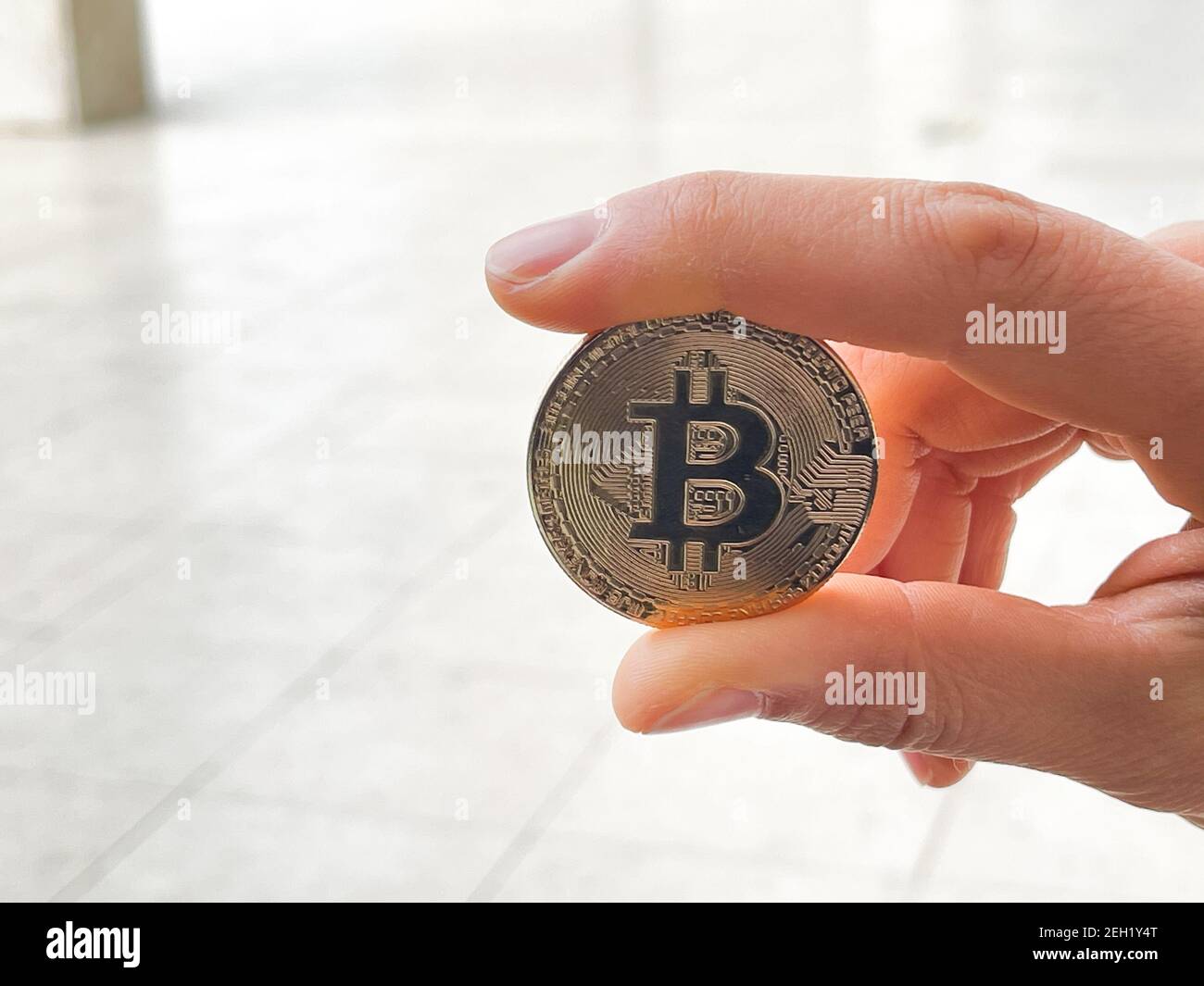 Female holding in her hand symbol of crypto currency . Stock Photo