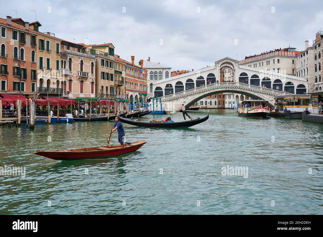 gondolas in front of typical Venetian house facades on the Grand Canal and Rialto bridge in the back, Venice, Veneto, Italy Stock Photo
