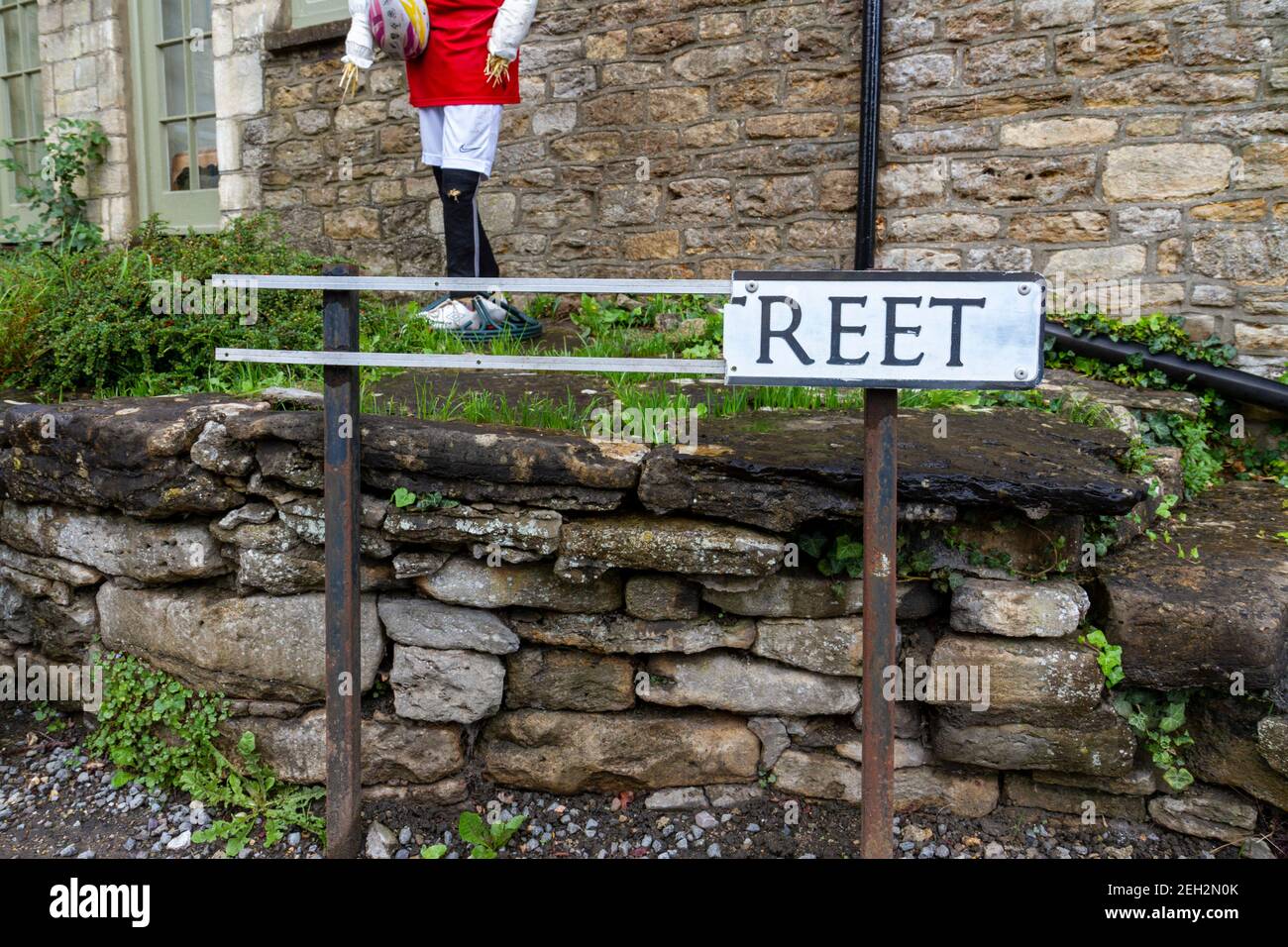 A severely damaged standard UK road name sign ('..reet' but should be 'Oxford Street' in Malmesbury, Wiltshire, UK. Stock Photo