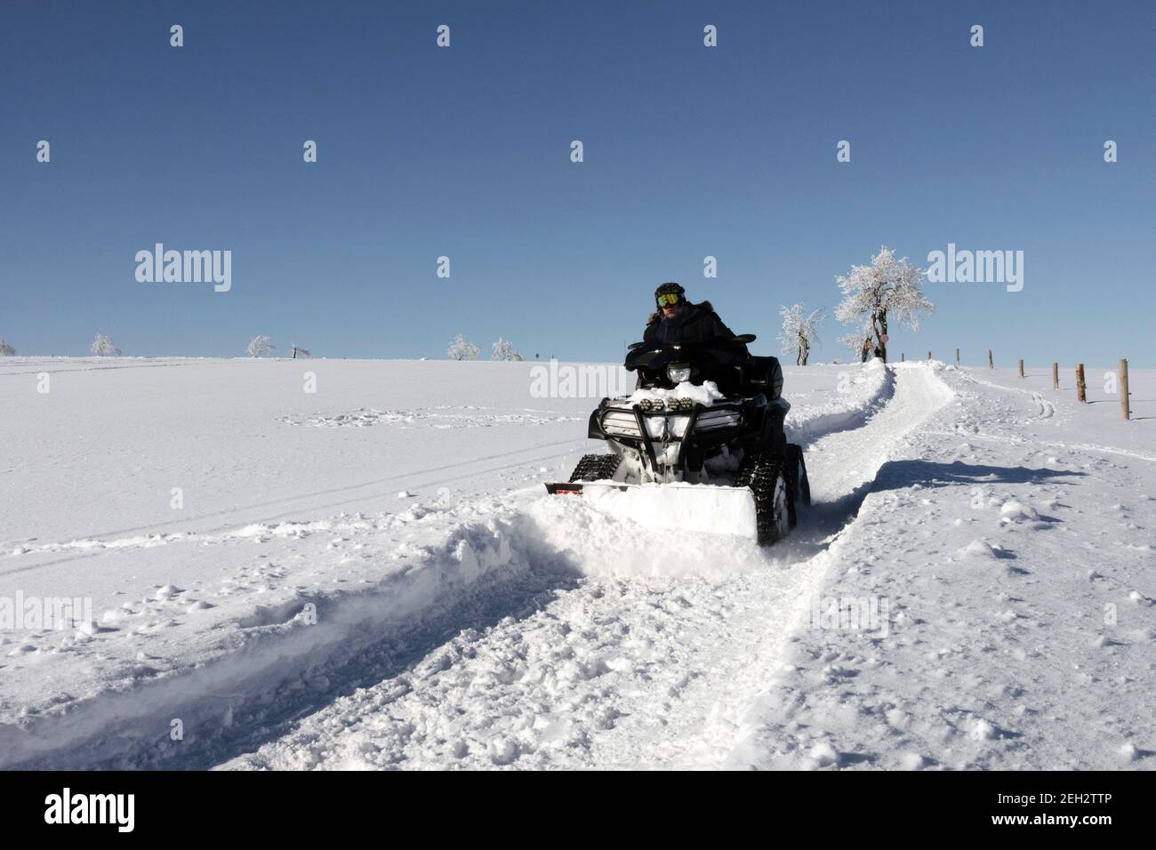 Plow snow quad path in field winter scene Stock Photo