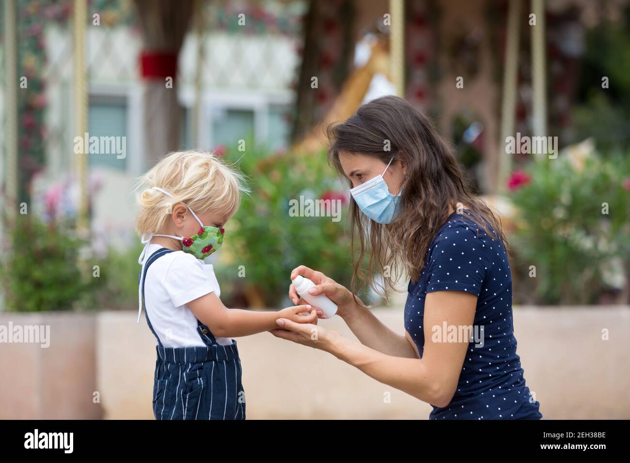 Mother and child, boy and mom, wearing masks and using disinfection outdoors Stock Photo Alamy