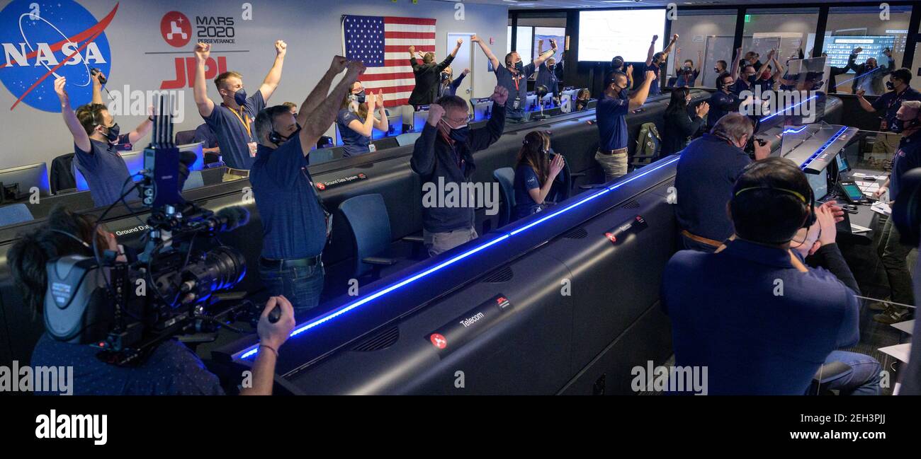 Members of NASA's Perseverance rover team react in mission control after receiving confirmation the spacecraft successfully touched down on Mars, Thursday, Feb. 18, 2021, at NASA's Jet Propulsion Laboratory in Pasadena, California. A key objective for Perseverance's mission on Mars is astrobiology, including the search for signs of ancient microbial life. The rover will characterize the planet's geology and past climate, pave the way for human exploration of the Red Planet, and be the first mission to collect and cache Martian rock and regolith. Photo Credit: (NASA/Bill Ingalls) Please note: Stock Photo