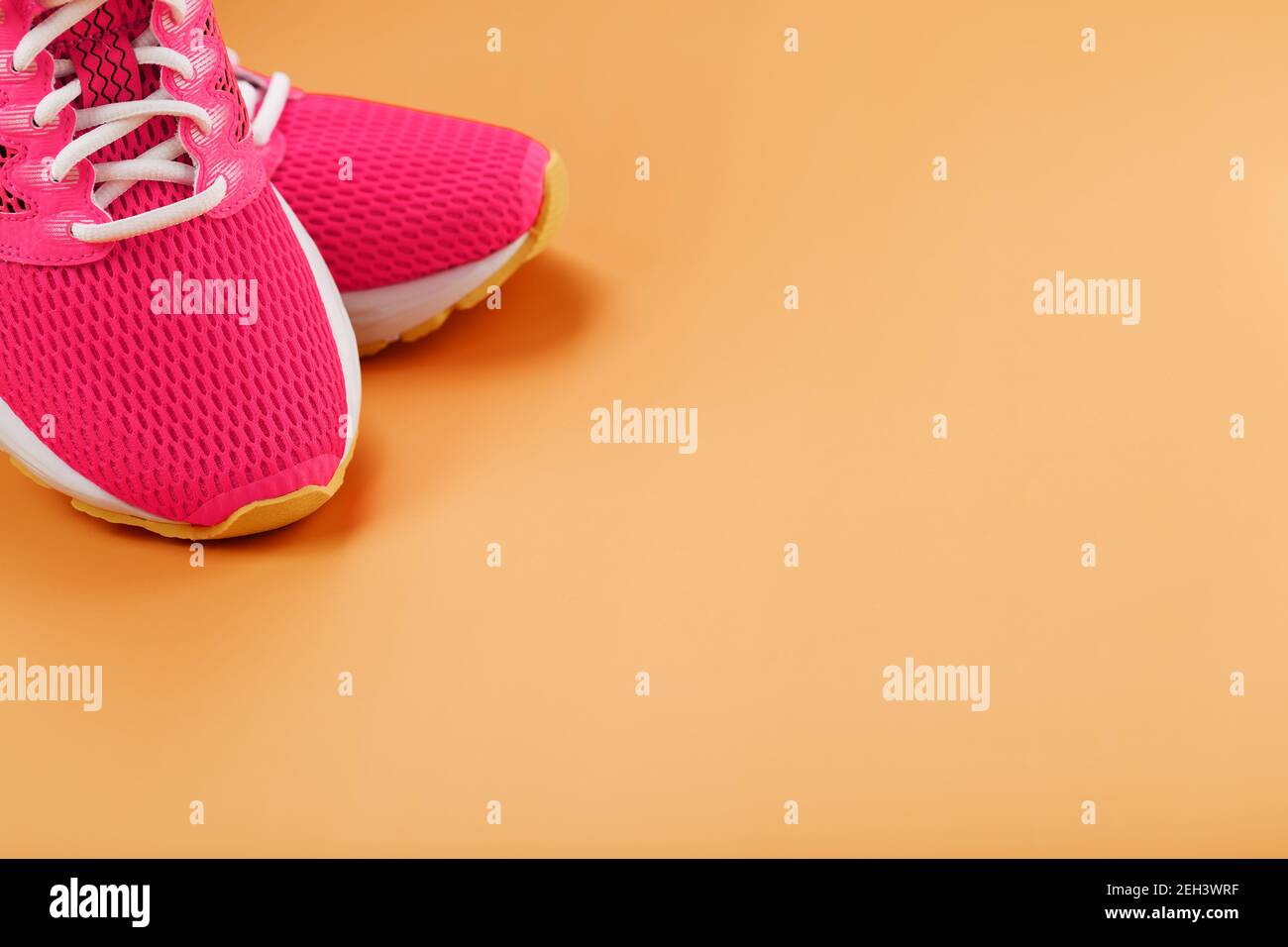 Sports sneakers, pink on a yellow background with free space. Top view ...