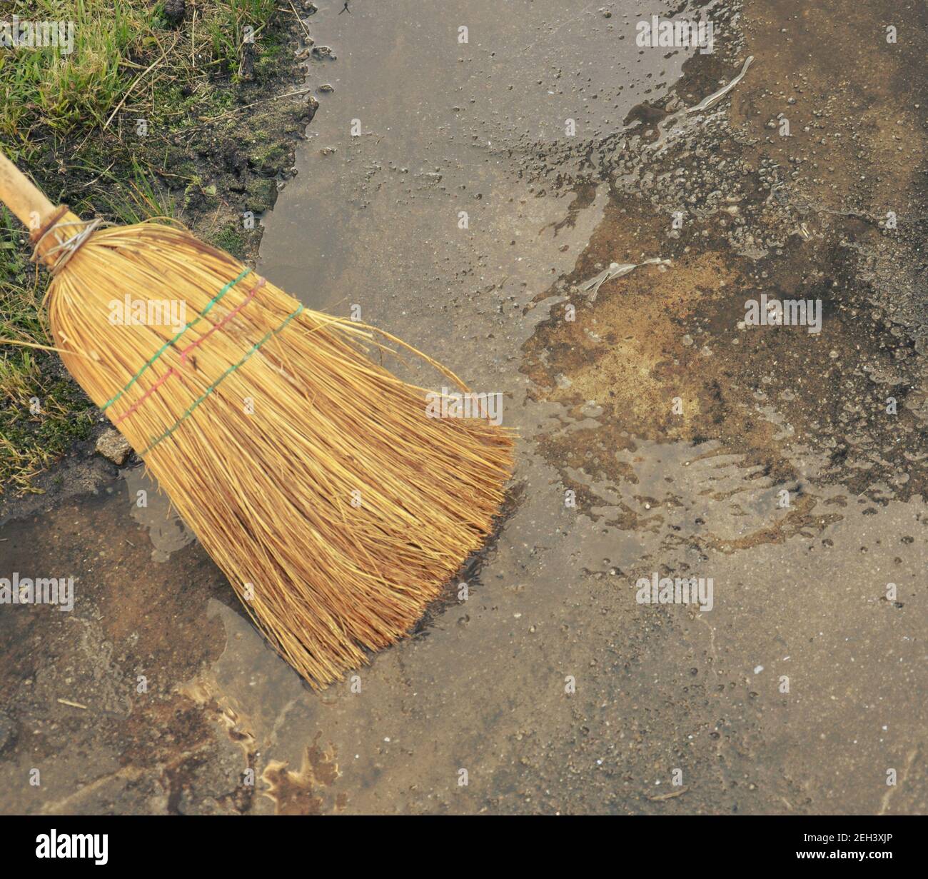 Sweeping the water yard with a straw broom, vintage view Stock Photo