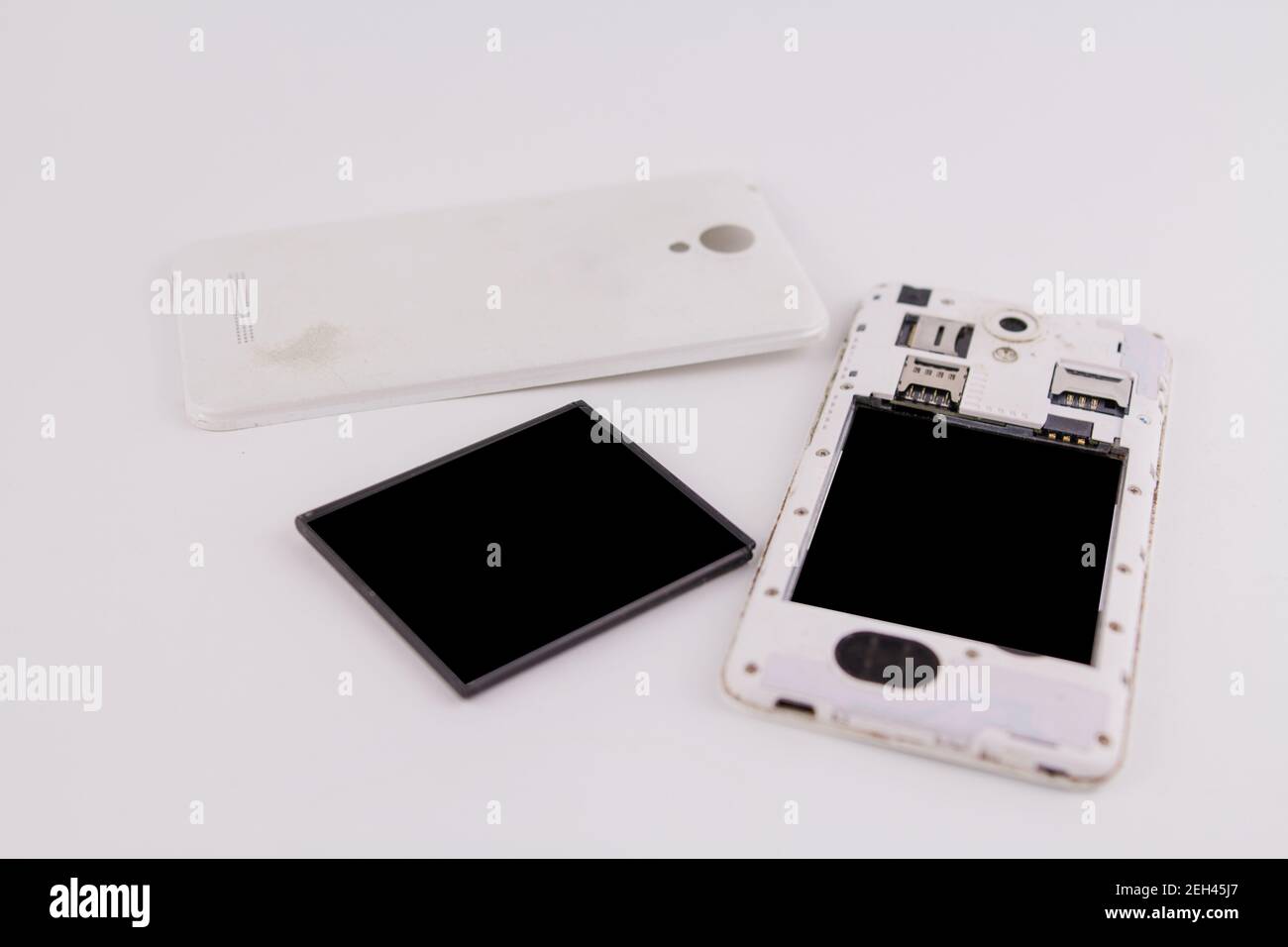a smartphone with removed cover and battery on white background phone repair Stock Photo