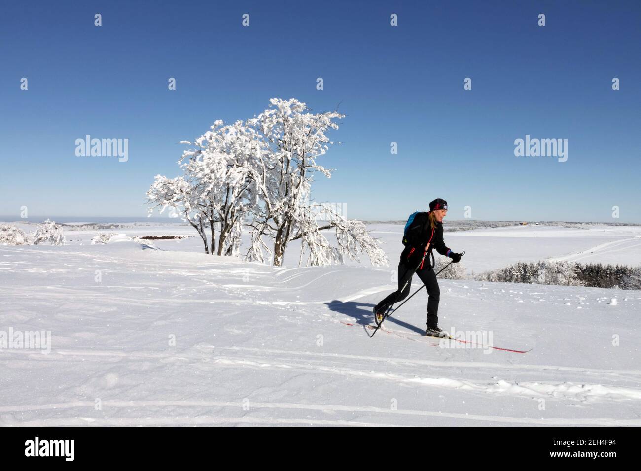 Woman skier skiing in snowy scene Mountains trail trip Sunny day Woman skiing Stock Photo