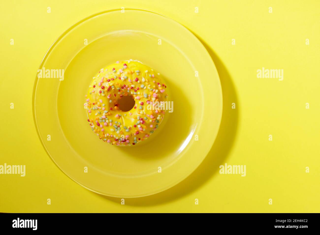 top view of donut with color toping on yellow plate and flat background Stock Photo