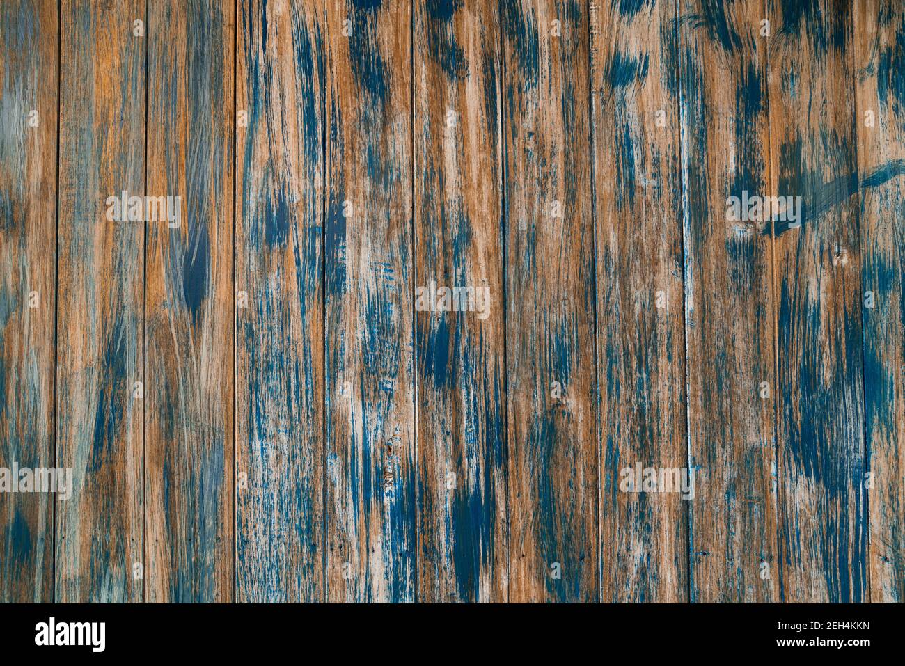 Faded aged wooden fencing with aged blue paint or stain with a rustic