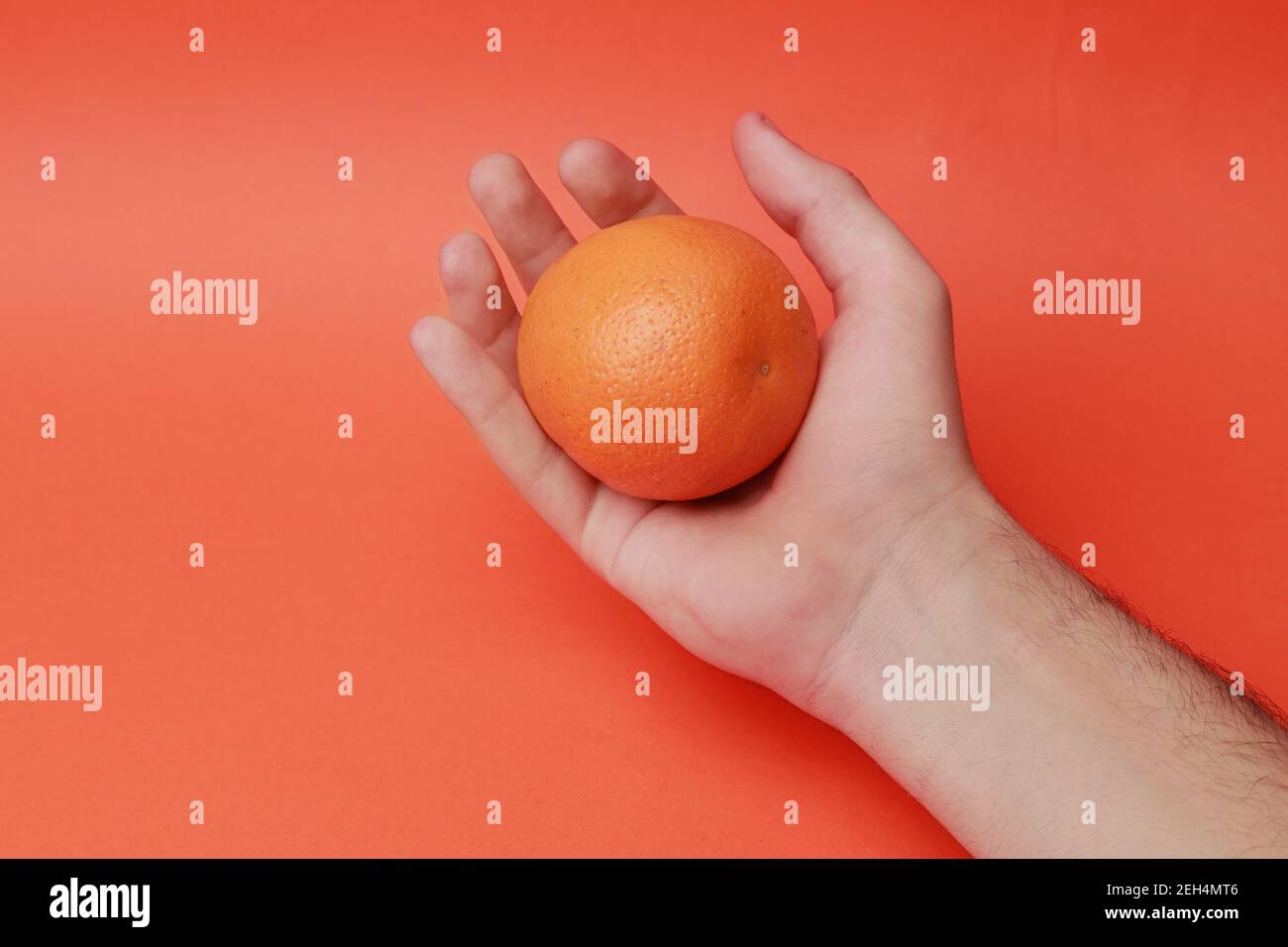 young man hand detail holding a organic orange Stock Photo