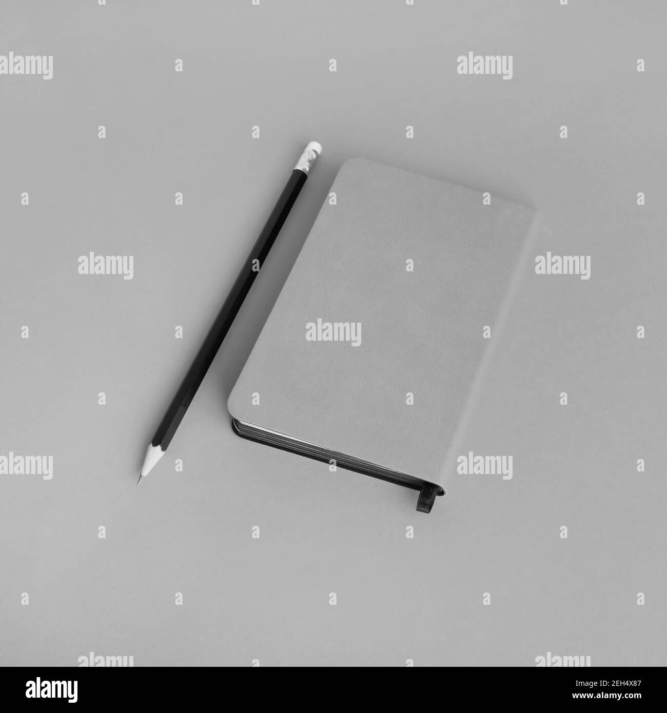 Blank notepad and pencil on gray paper background. Template for branding design. Stock Photo