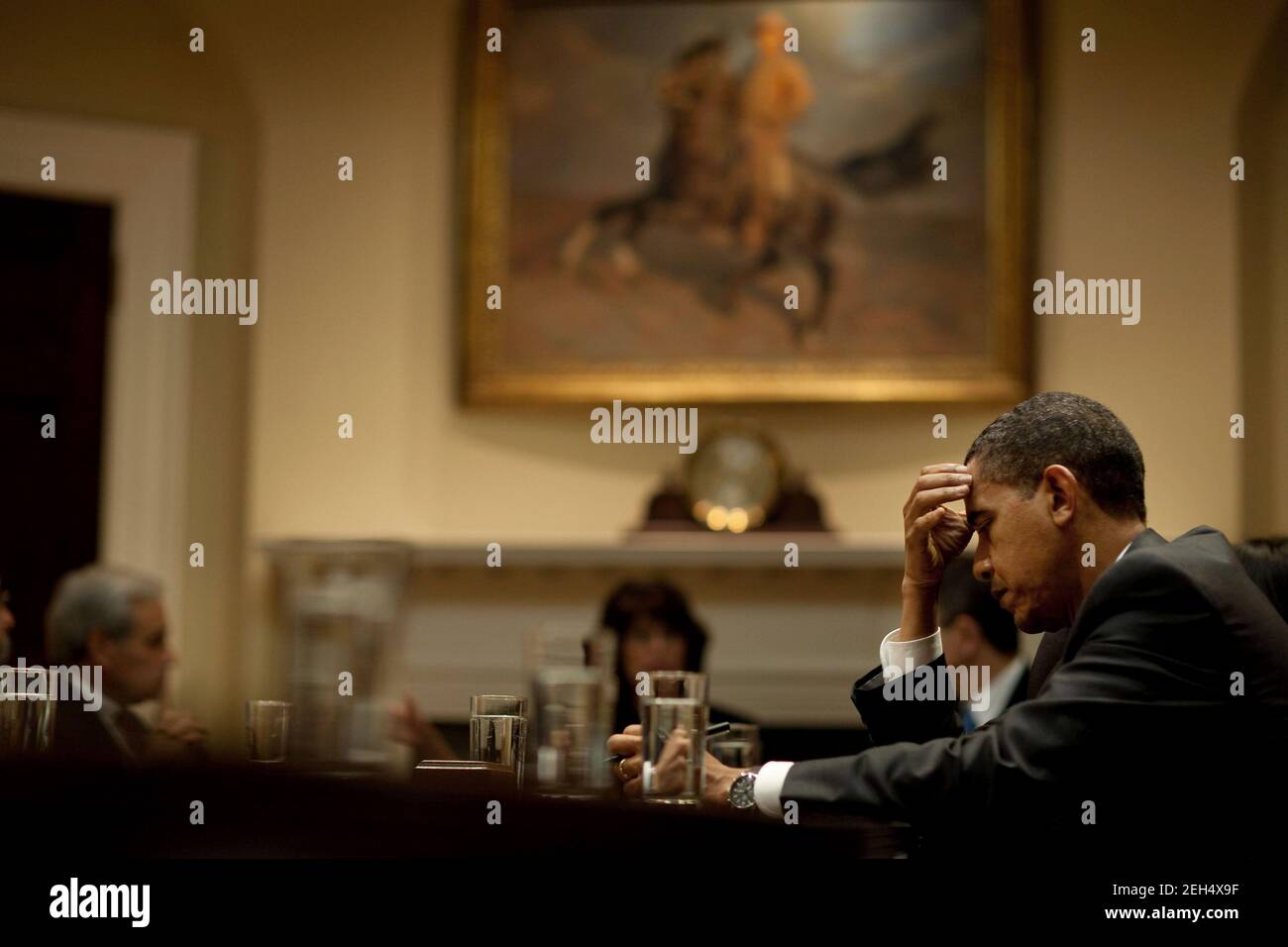 President Barack Obama jots down notes as he meets with leaders of the Progressive, Black, Hispanic and Asian Pacific Caucuses in the Roosevelt Room of the White House, Oct. 29, 2009. Stock Photo
