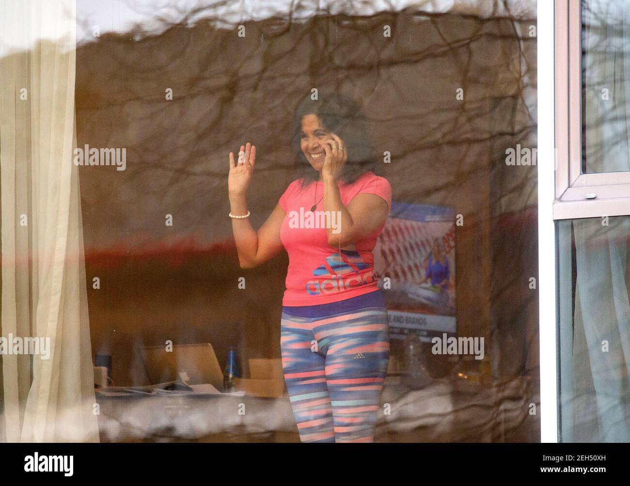 London, UK. 19th Feb, 2021. A woman in Quarantine waves out of the window. People in 10 day quarantine at the Radisson Blue Edwardian Hotel. People are flying via Heathrow, but the new quarantine restrictions for international travel from so called 'red list' countries means that the law requires quarantine in one of the Government approved hotels. National Lockdown 3 is in force with the Government instruction for everyone to stay at home. Credit: Mark Thomas/Alamy Live News Stock Photo