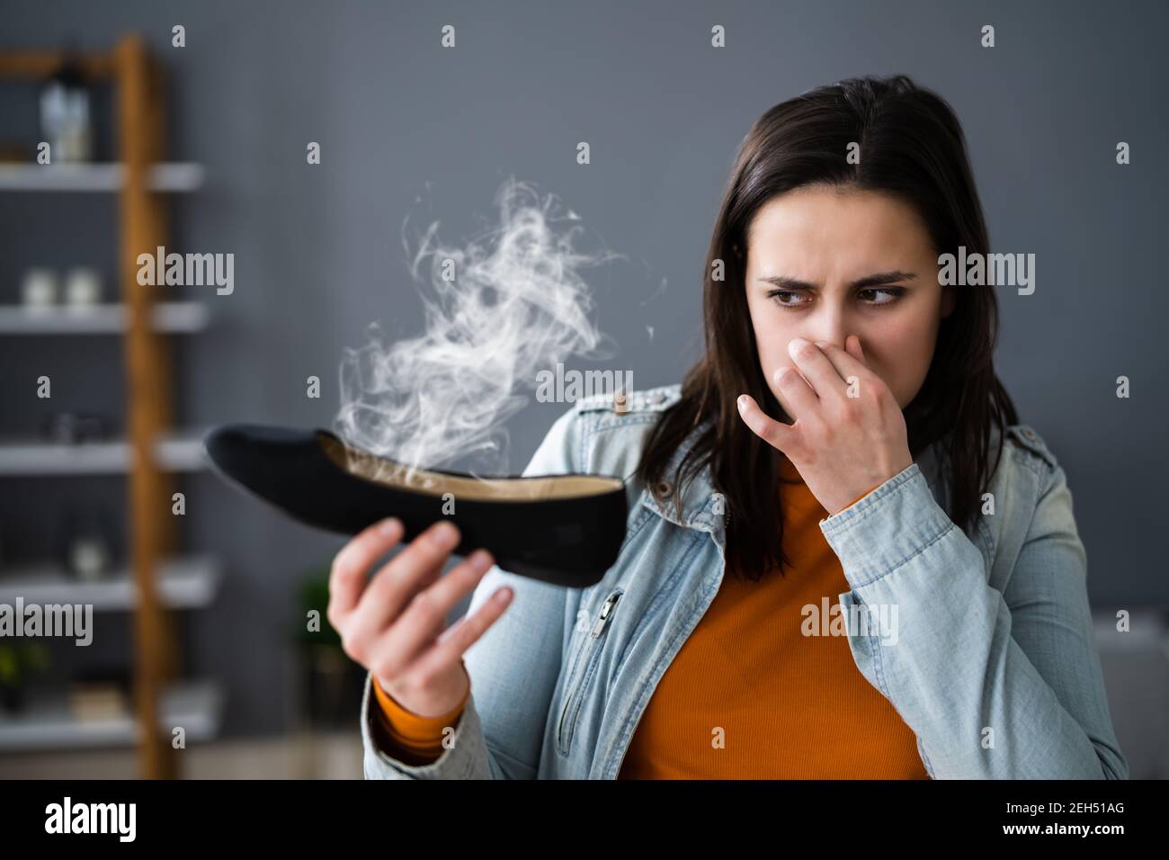Woman Smelling Stinky Shoes. Feet Sweat And Odor Stock Photo