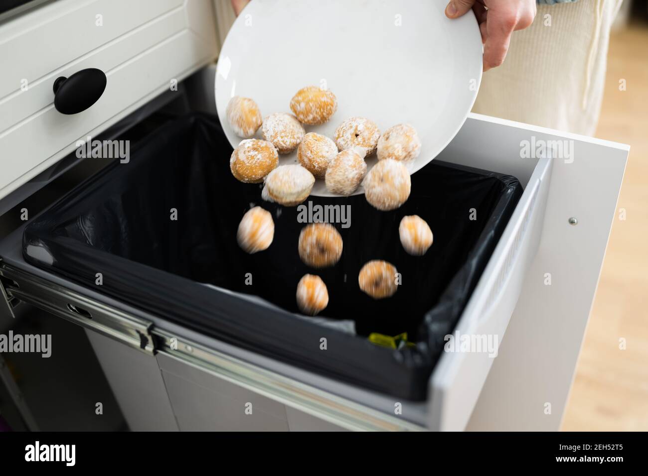 Throwing Away Leftover Food In Trash Or Garbage Dustbin Stock Photo