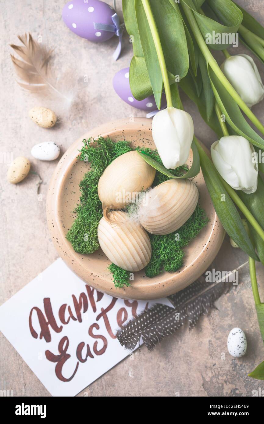 Easter composition with wooden Easter eggs and spring flowers tulips on ...