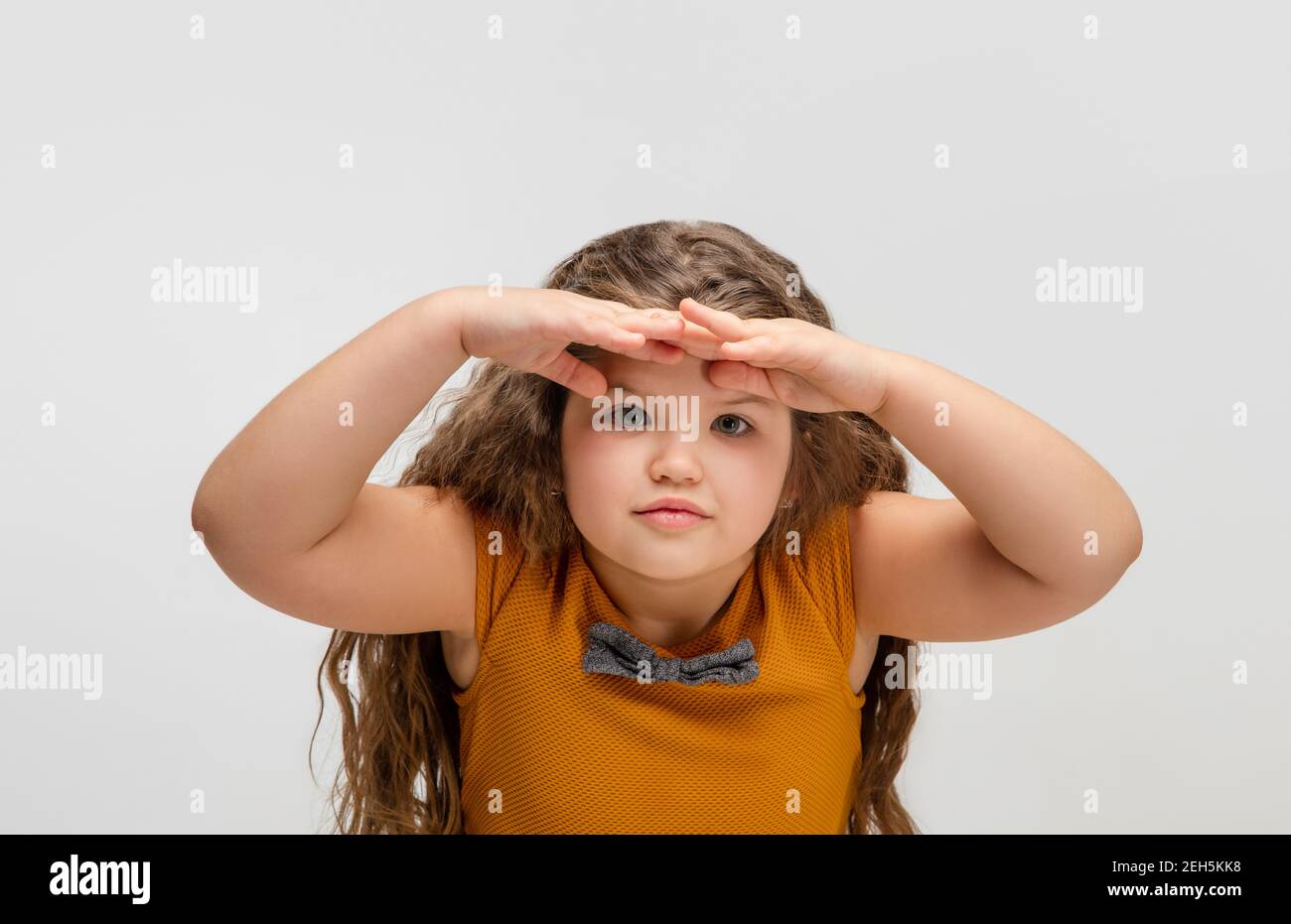 Look out. Happy, smiley little caucasian girl isolated on white studio ...