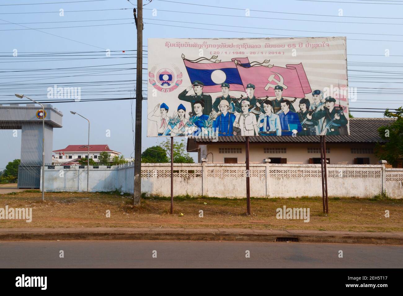 Thak Hek, Laos - April, 2015: Big banners with drawing of Communist propaganda with flags and people along the road Stock Photo
