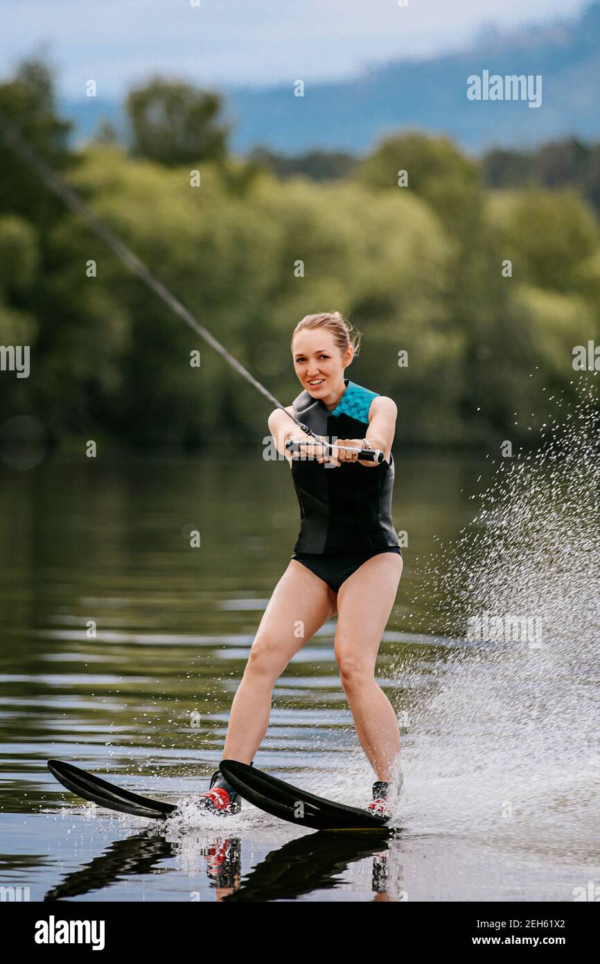 young woman on water ski in summer lake Stock Photo