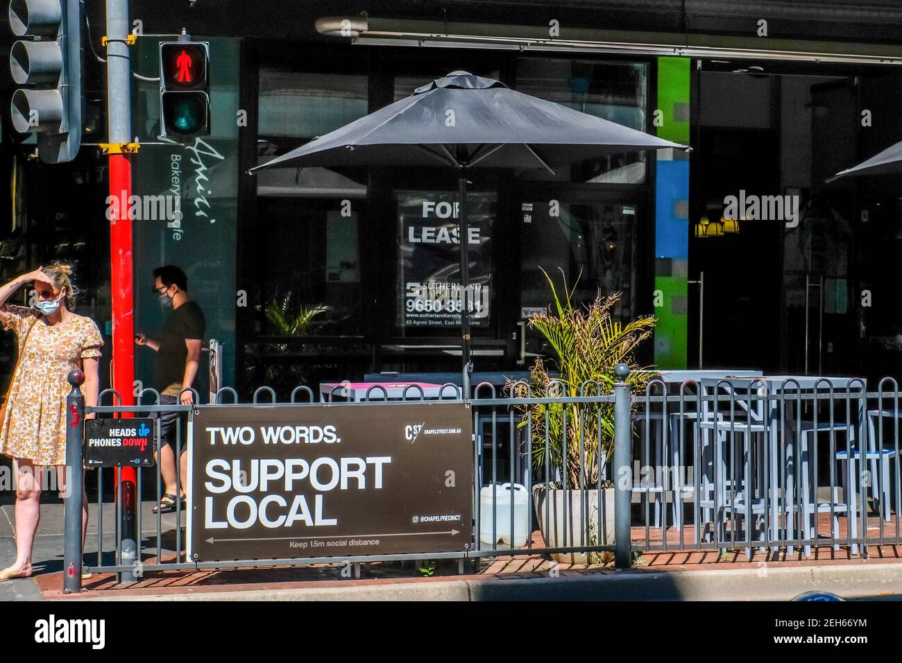 Melbourne, Australia. 18th Feb, 2021. A woman waiting at the pedestrian crossing with a retail space for lease in the background on a empty commercial retail property on Chapel Street precinct. Credit: SOPA Images Limited/Alamy Live News Stock Photo